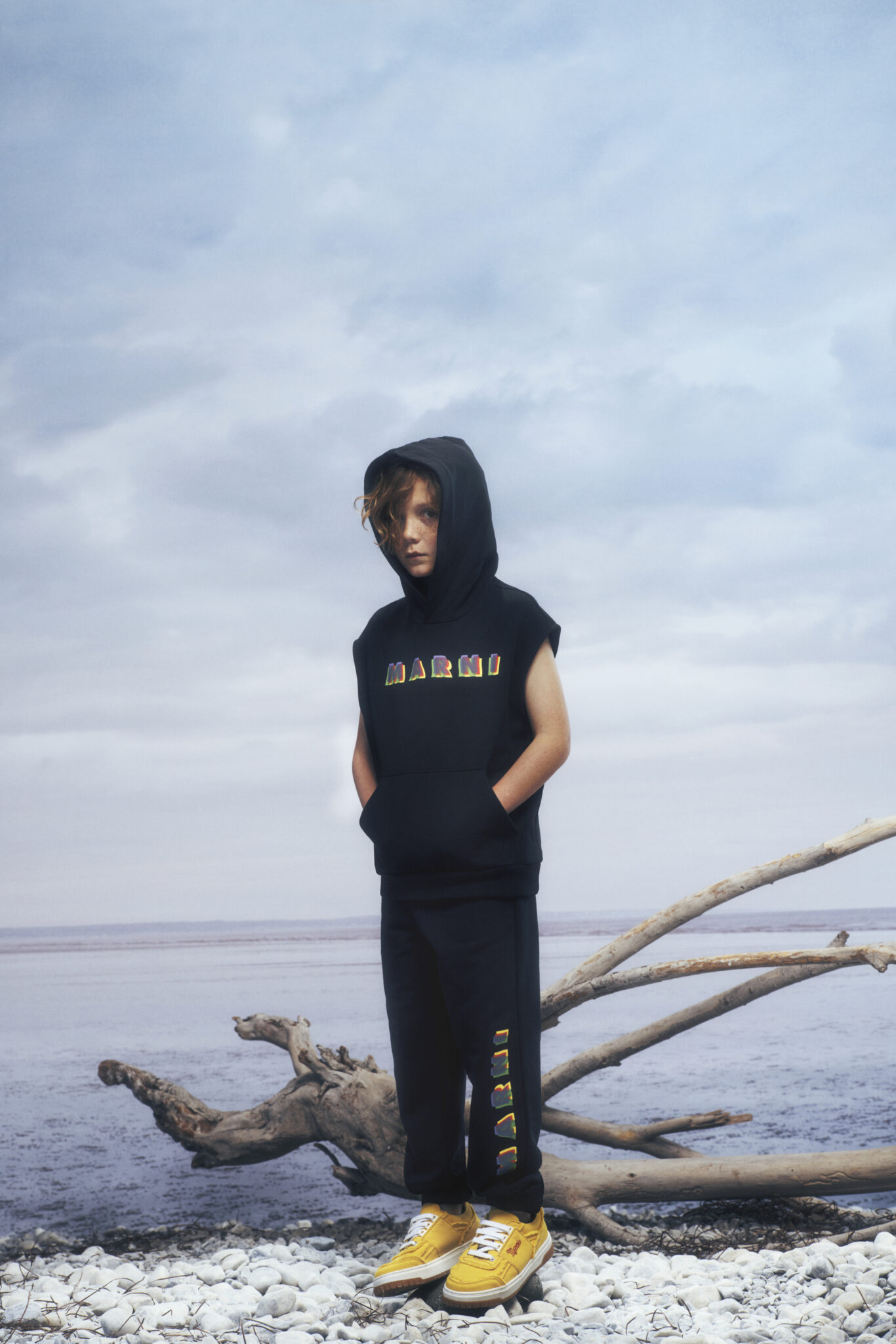 kid wearing black tracksuit on the seaside