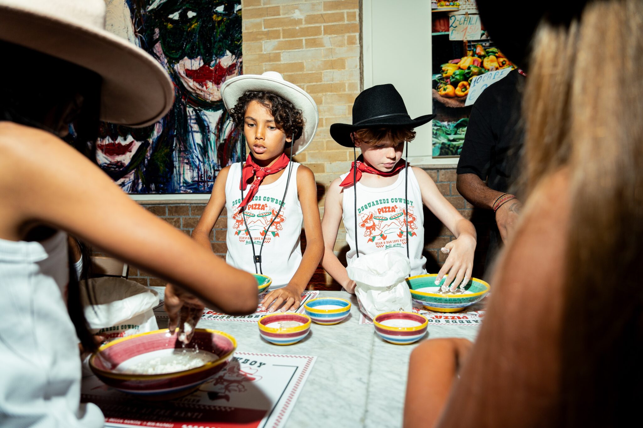 Imagine kids dressed in custom-printed tank tops, denim shorts, Western boots, hats, and red bandanas