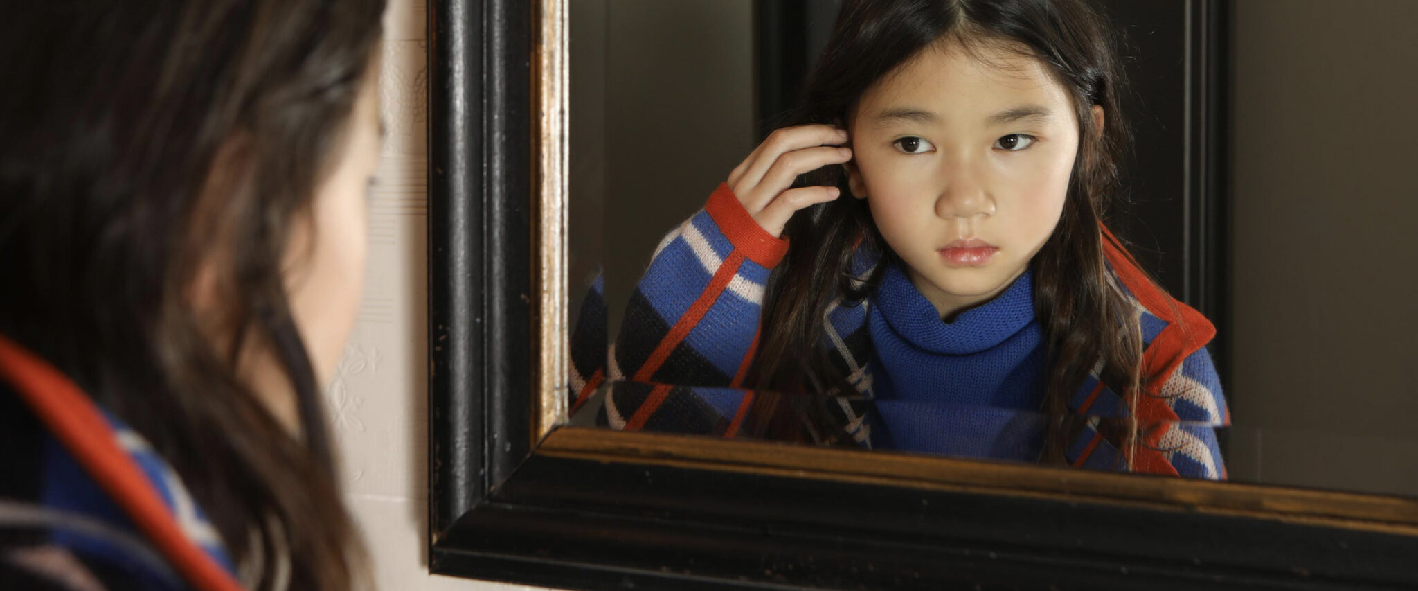 bambina asiatica guarda nello specchio