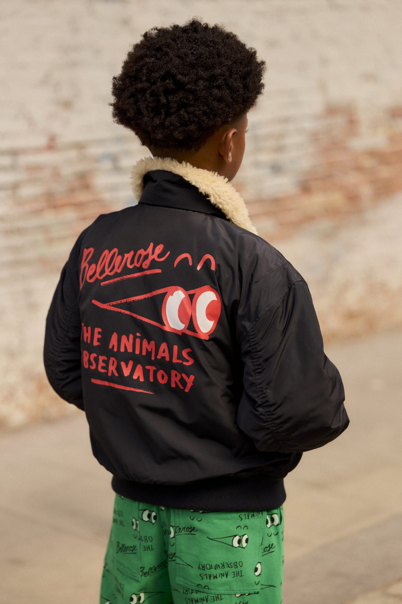 A child wearing a black bomber jacket with 