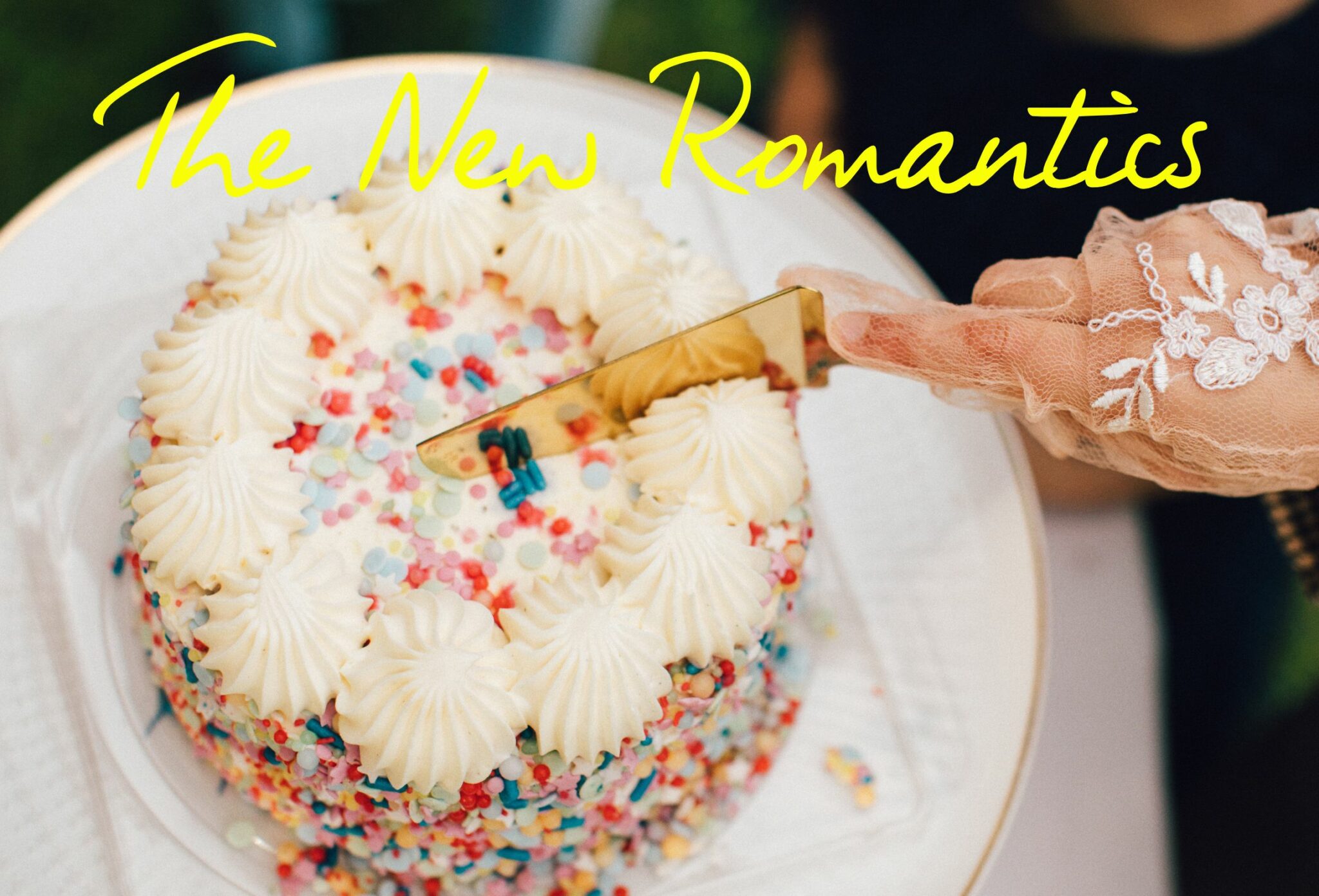 A colorful cake covered in sprinkles with intricate icing decorations. A hand, wearing an elegant lace glove, is seen slicing the cake with a golden knife. The bright yellow text