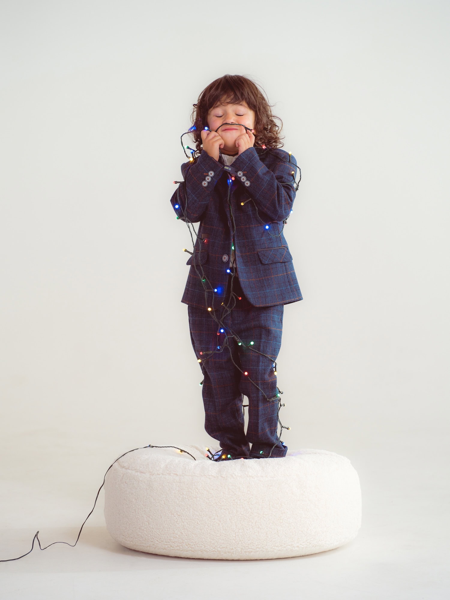 kid playing with christmas lights