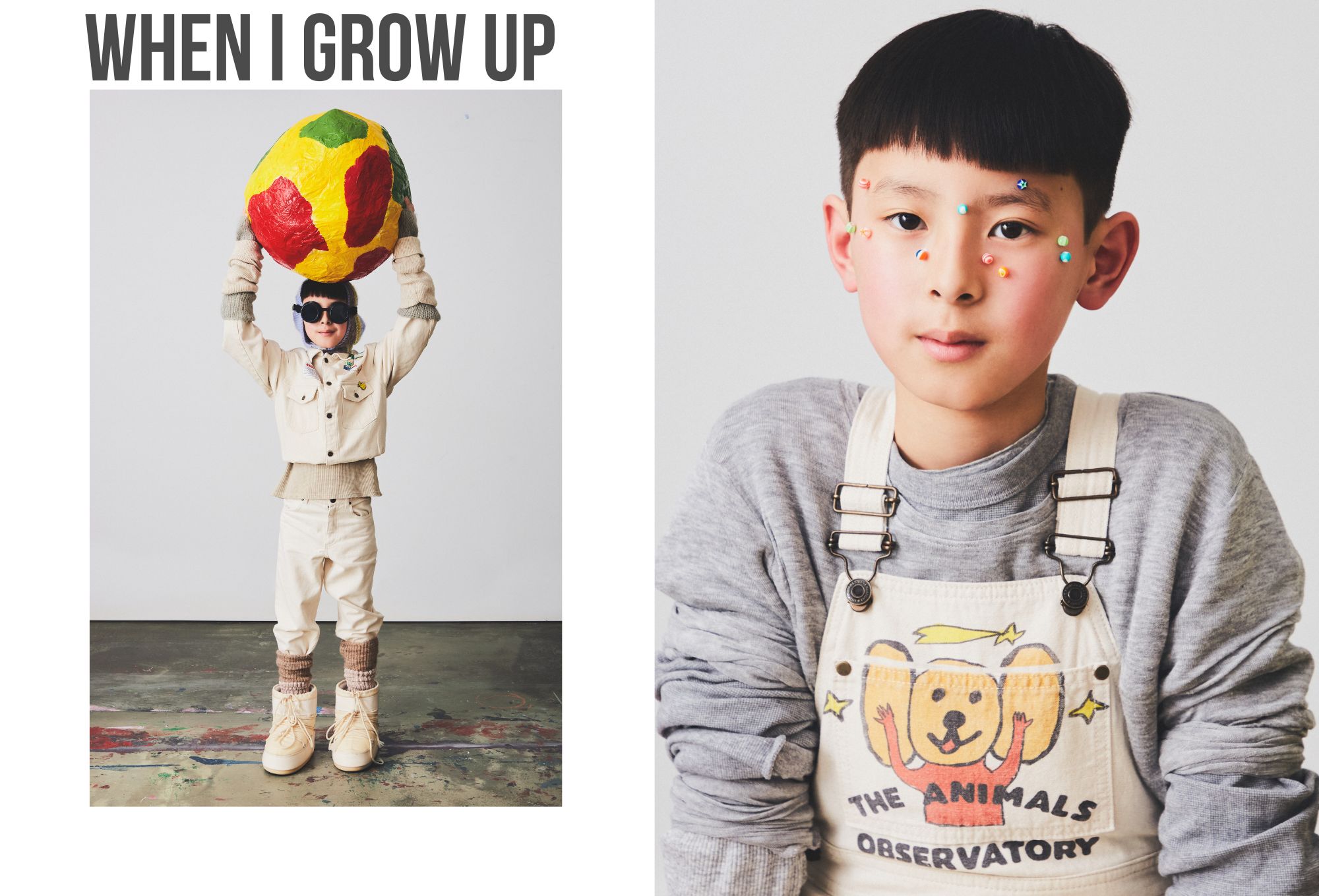 Children's fashion editorial featuring two boys in playful, creative outfits. On the left, a boy wearing cream-colored trousers and a matching jacket holds a large, colorful paper-mâché globe above his head. He accessorizes with sunglasses, earmuffs, and chunky boots layered with thick socks. On the right, a close-up of a boy in off-white overalls with a cartoon bear graphic and the words “THE ANIMALS OBSERVATORY,” worn over a grey sweatshirt. His face is decorated with colorful stickers, adding a whimsical touch. Bold text at the top reads “WHEN I GROW UP.”