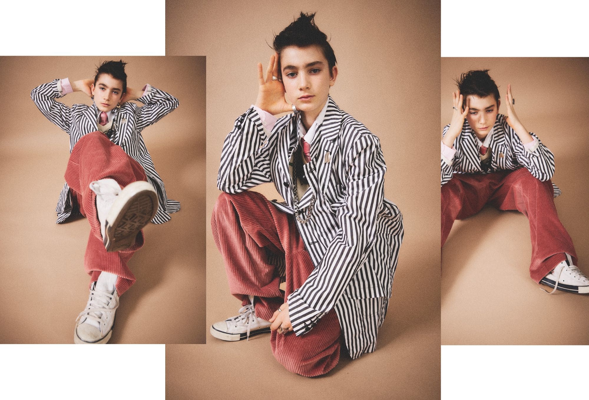Fashion editorial by Molly Magnuson featuring a young model in three dynamic poses against a beige backdrop. The model wears a bold black-and-white striped oversized blazer layered over a shirt and tie, paired with wide red corduroy pants and white high-top sneakers. The styling blends a punk-inspired aesthetic with playful tailoring, emphasizing texture and contrast. The model's hair is styled in a tousled, spiky look, adding edge to the expressive and relaxed poses.