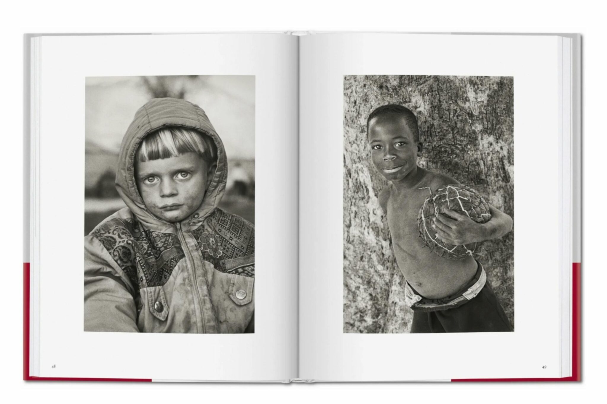 Double-page spread from Sebastião Salgado’s book “Children,” showing two black and white portraits. On the left, a young boy with a serious expression wears a patterned hooded jacket. On the right, a smiling boy poses shirtless against a tree, holding a handmade ball.