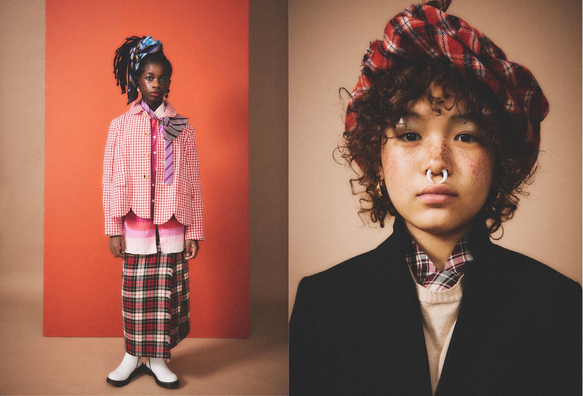 Fashion editorial by Molly Magnuson featuring two young models styled in bold, clashing prints and layered textures. On the left, a model stands against a vivid orange backdrop wearing a red gingham jacket over a striped shirt, paired with a plaid skirt, layered ties, and white boots. A sculptural blue headwrap and drop earrings complete the eclectic look. On the right, a close-up of a second model showcases a soft expression, wearing a red plaid beret, black coat, cream sweater, and plaid shirt underneath, accessorized with a septum ring and gold hoop earrings. The styling merges punk attitude with vintage charm.
