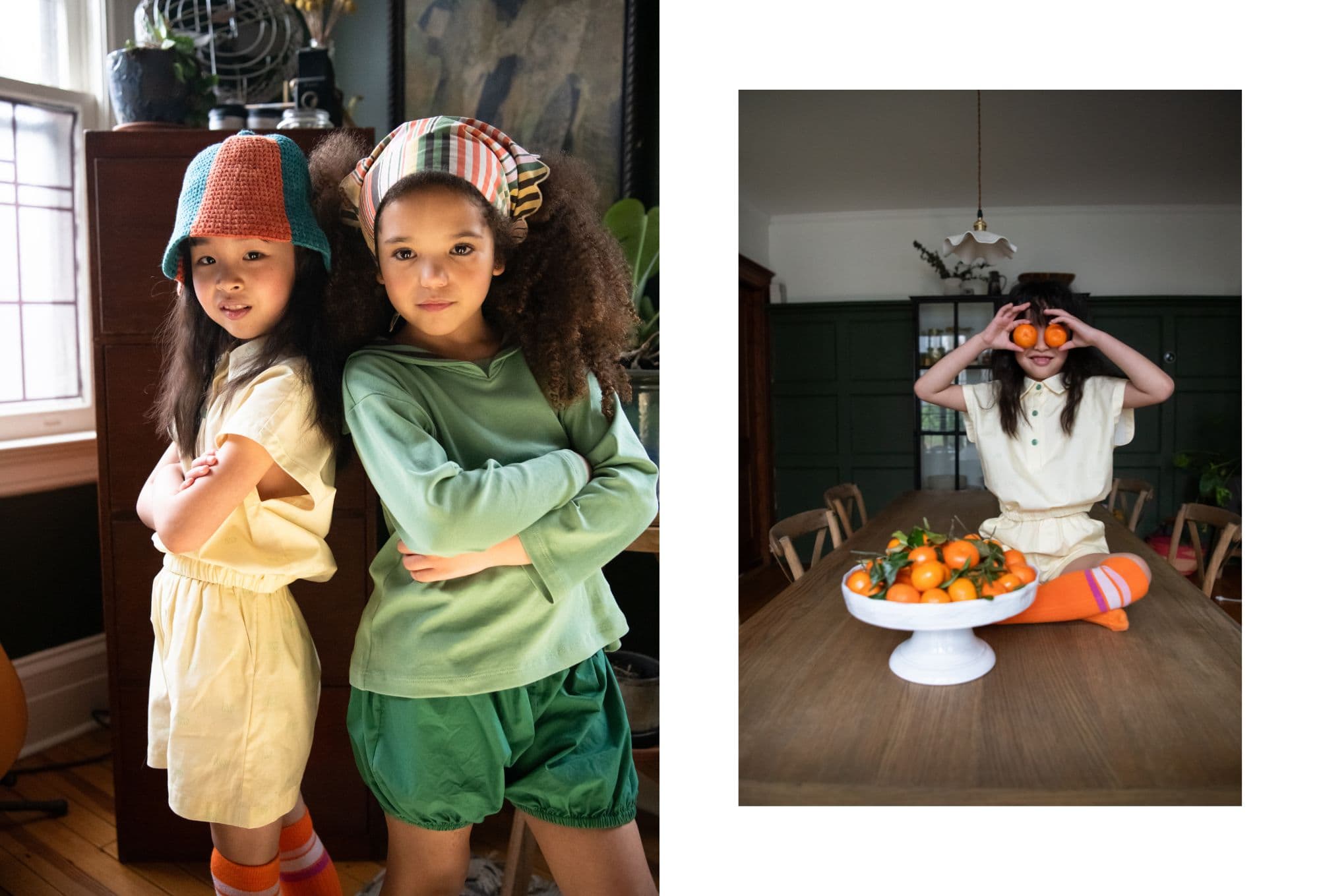 On the left, two girls pose back-to-back with crossed arms in a cozy, warmly lit room. The girl on the left wears a pale yellow outfit with a crochet bucket hat in teal and orange, while the girl on the right wears a green long-sleeve top, matching shorts, and a striped headscarf. On the right, the same girl in yellow playfully sits on a wooden table holding two tangerines over her eyes like glasses, with a white bowl full of more tangerines in front of her. She wears bright orange and pink striped knee-high socks. Photo by Sabrina Helas.