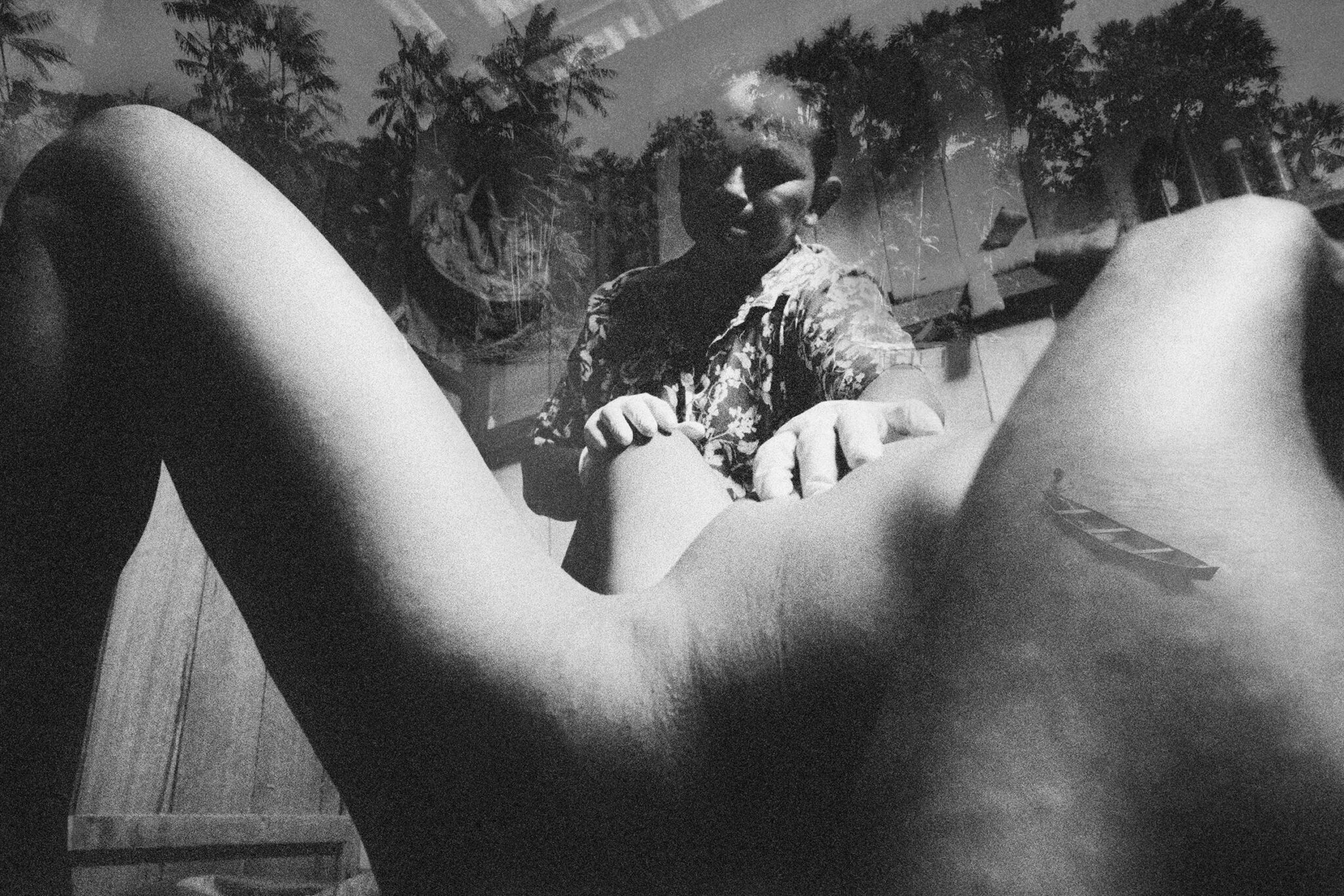 Black and white photographs from The Enchanted Ones by Stephanie Pommez, Kehrer Verlag, featured on Scimparello Magazine. Top: Ribeirinho midwife assisting childbirth in a poetic Amazonian scene. Bottom: young father holds a child inside a wooden house, another child in the background.