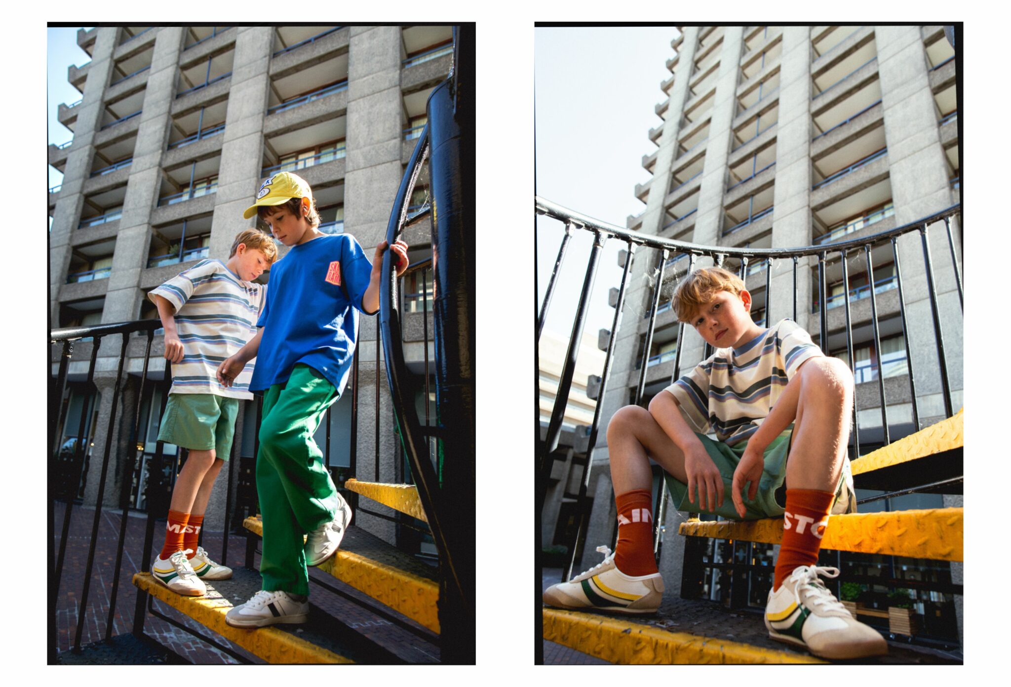 Sebastian and Oliver on a yellow metal spiral staircase in an urban setting, wearing SS25 looks — Sebastian in striped oversized T-shirt by The Animals Observatory, green shorts by The New Society, rust orange socks by The Animals Observatory, and retro sneakers by Gucci; Oliver in cobalt blue T-shirt and green trousers by The Animals Observatory, yellow cap by Bobo Choses, and white sneakers by Adidas. Photo by Hannah Mentz for Scimparello Magazine.
