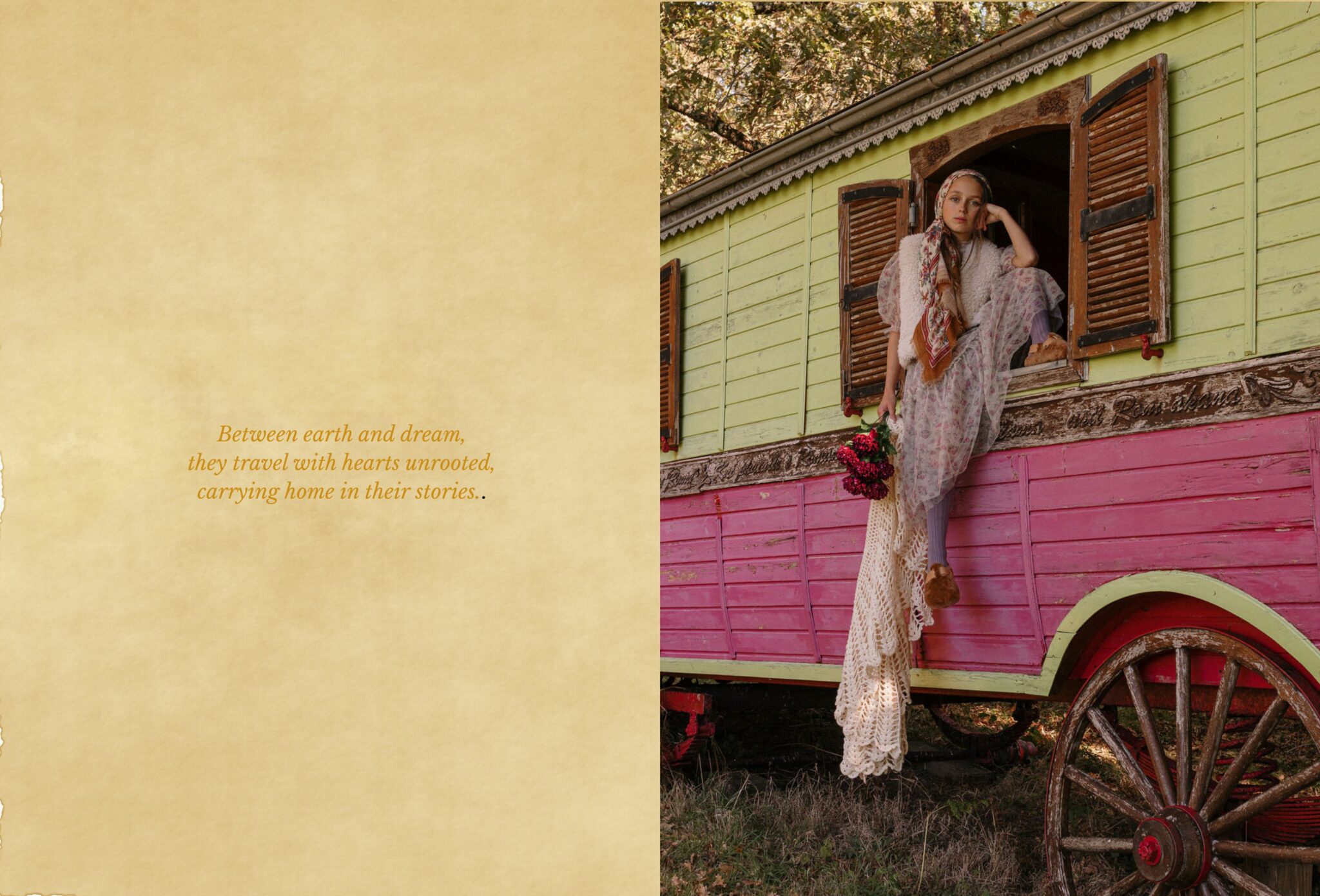 Girl wearing a floral dress, shawl, and headscarf leans out of a vintage gypsy caravan painted pink and green, holding flowers and a crochet blanket. Kids fashion editorial COVEN II – Mystical Folklore Gypsy by Lara Lutz for Scimparello Magazine.