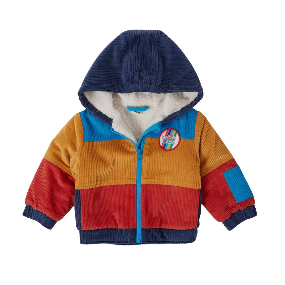 Multicolor corduroy hoodie by GOLDIE + ACE, featured on Scimparello Magazine. Bright retro tones, sherpa lining, and a playful badge make it a fun FW25 kidswear piece.