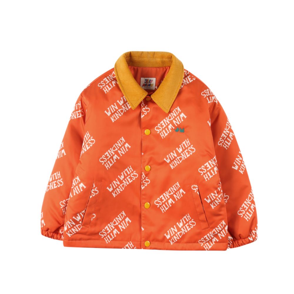 Orange FW25 jacket by JELLY MALLOW with “Win With Kindness” print and contrast corduroy collar, featured on Scimparello Magazine. A bold and cheerful kidswear piece.