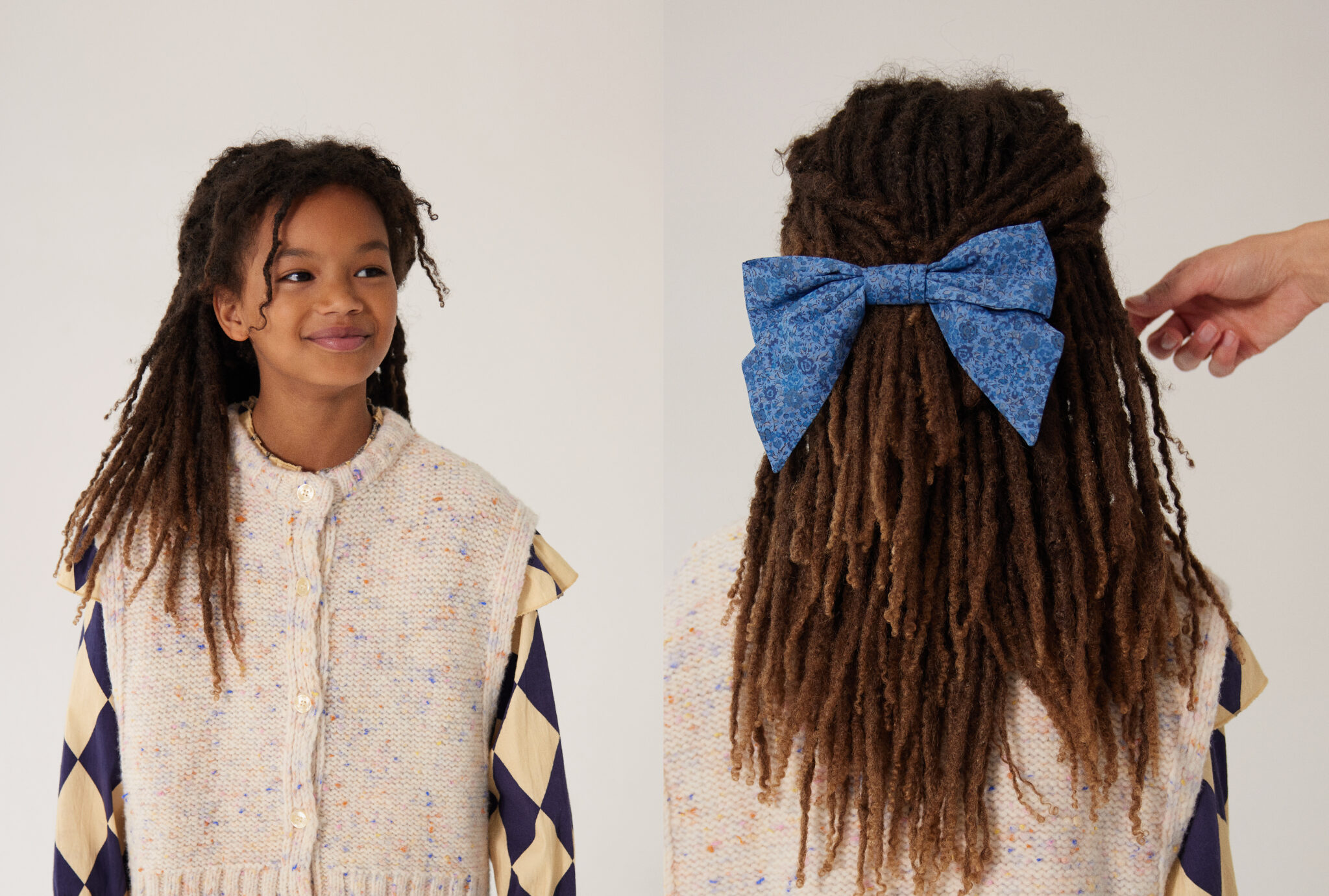 Girl smiling and showing the back of her hairstyle with a large blue bow TANGERINE, wearing blouse MAISON MANGOSTAN and knitted vest BELLEROSE. From Dancing With Myself FW25 by Alex Klever for Scimparello Magazine – a tender portrait celebrating color, texture, and individuality.