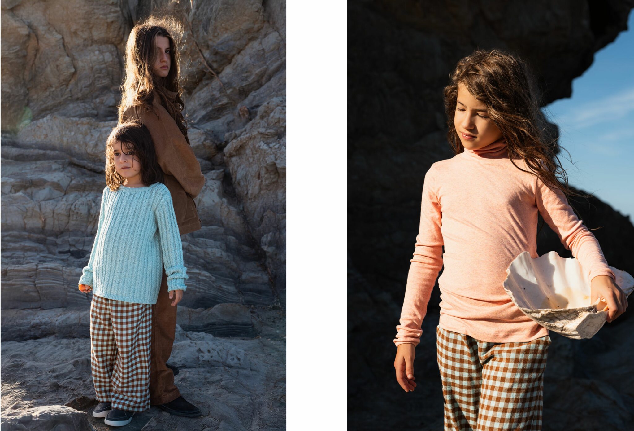 Girl standing on coastal rocks holding a large shell, wearing a peach long-sleeve top and checked trousers in the afternoon light. Photo by Manuela Franjou for Scimparello Magazine.Two children standing on rocky coastal terrain, one wearing a light blue knit sweater and checked trousers, the other in a brown jacket and trousers. Photo by Manuela Franjou for Scimparello Magazine.