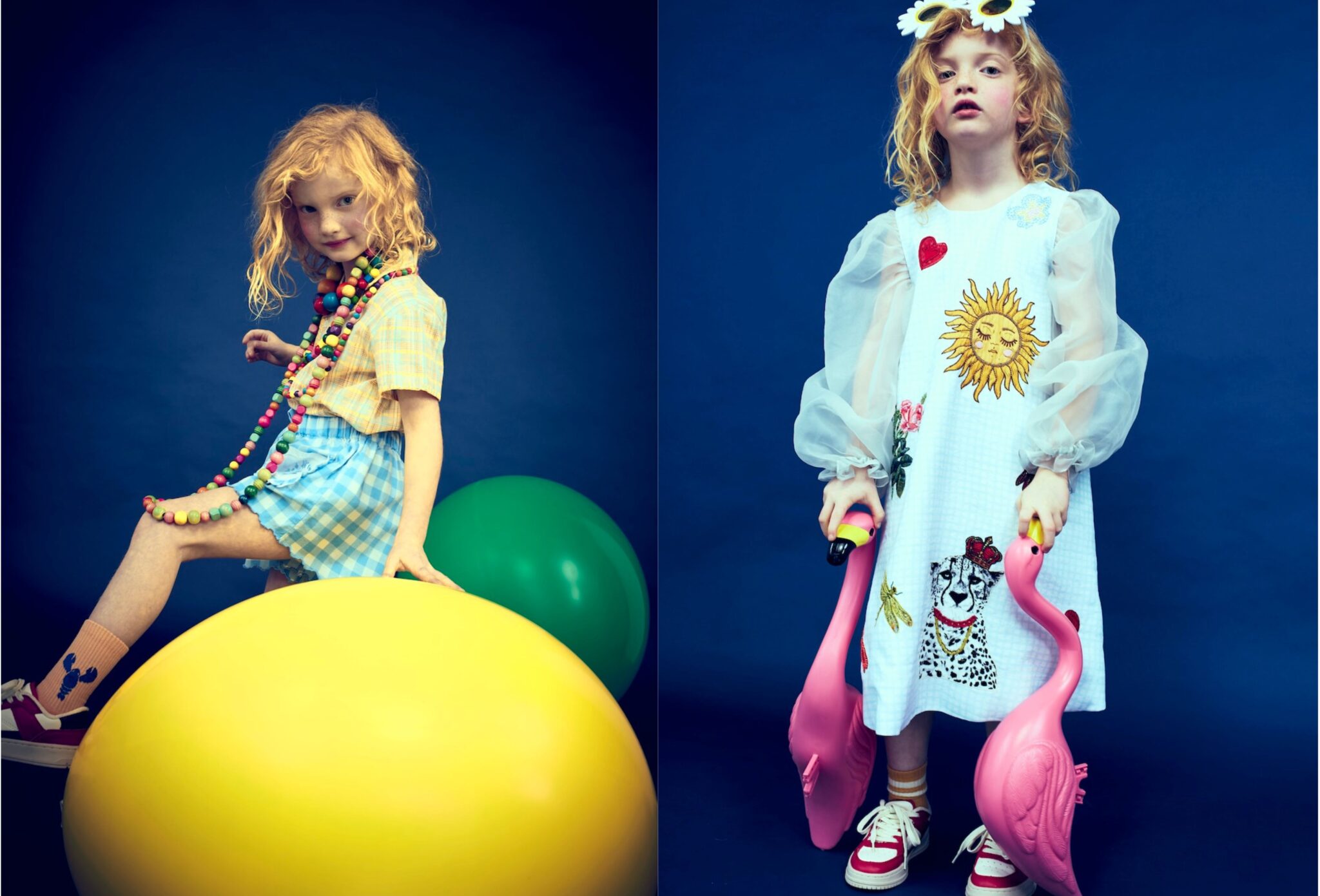 Kids fashion editorial Funky Monkey for Scimparello Magazine featuring a red-haired child in a deep blue studio: on the left, sitting on oversized yellow and green balls wearing a pastel checked top, blue gingham skirt and colorful beaded necklaces; on the right, standing in a light blue dress with sheer puff sleeves and playful embroidered motifs, holding two pink flamingo toys and wearing red sneakers. Photo by Valerie Mathilde.