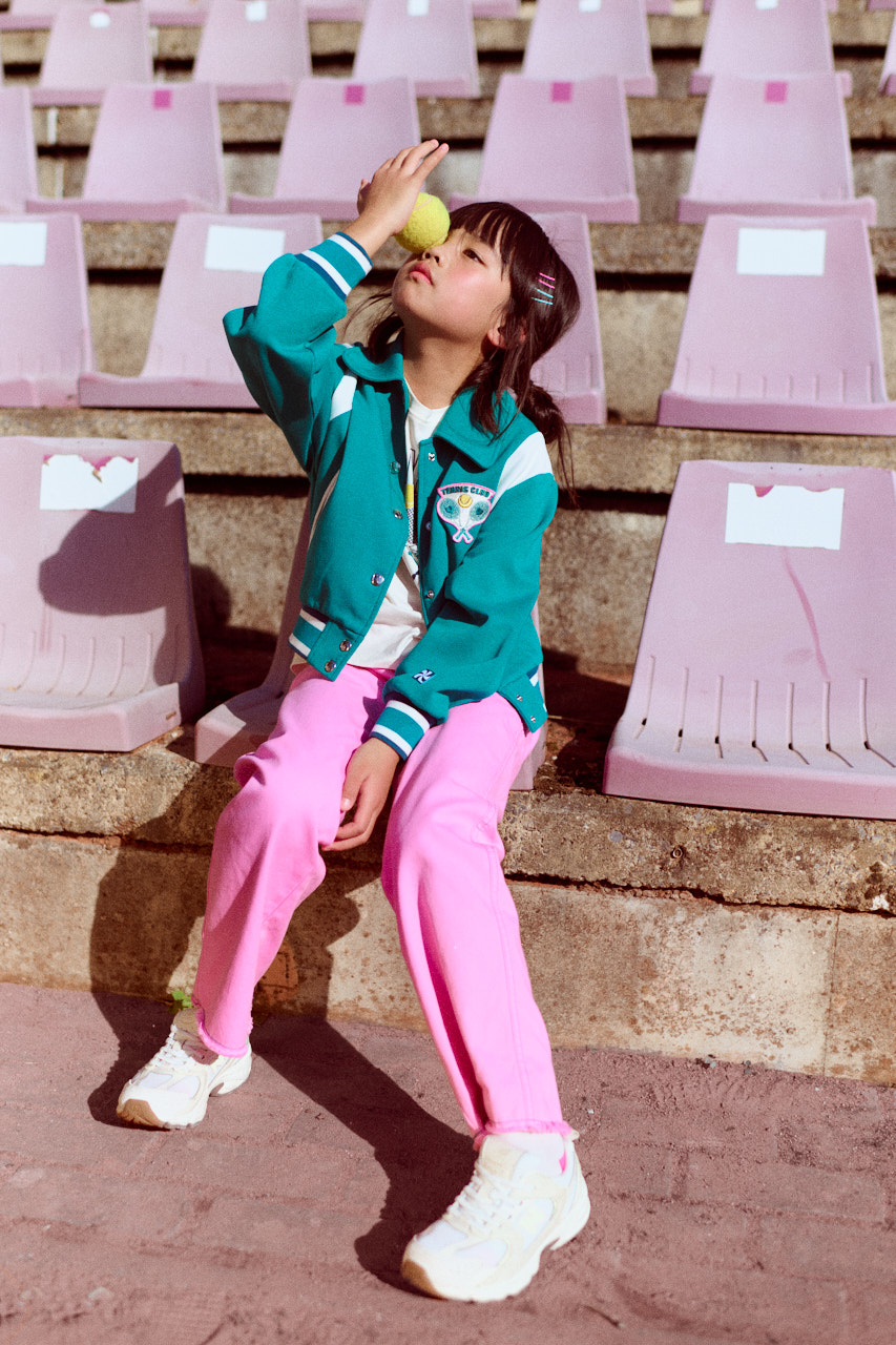 girl wears green jacket and pink trousers, sporty look for SS26 campaign