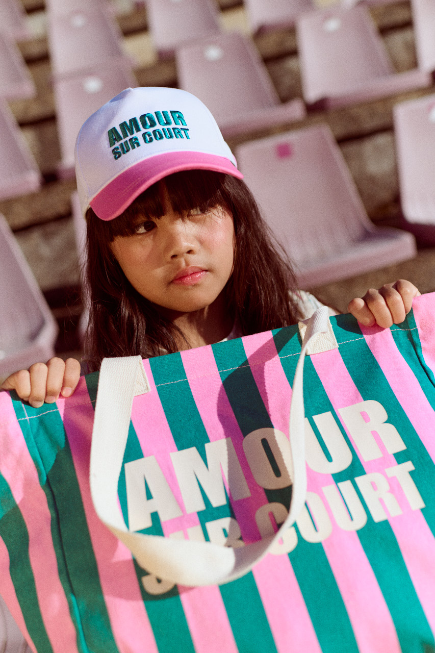 girl with baseball cap and striped maxi bag, fashion and french riviera look