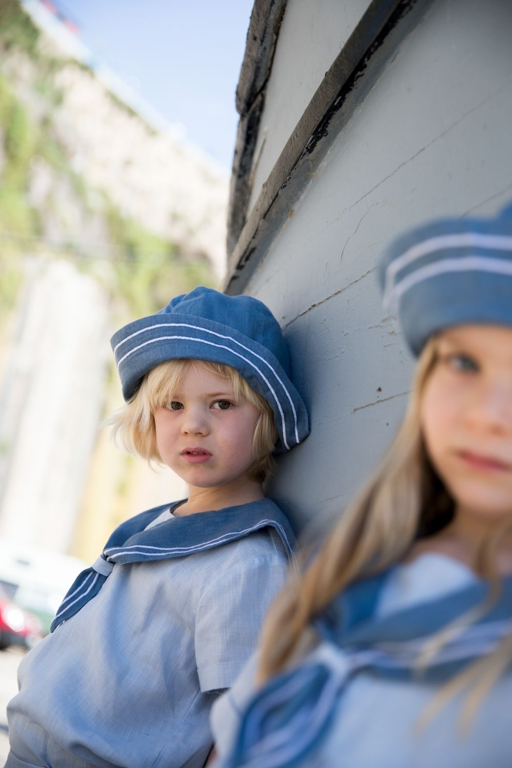 MarMar Copenhagen SS26 close-up portrait of children in blue sailor outfits leaning against a boat – kids fashion campaign, Scimparello Magazine