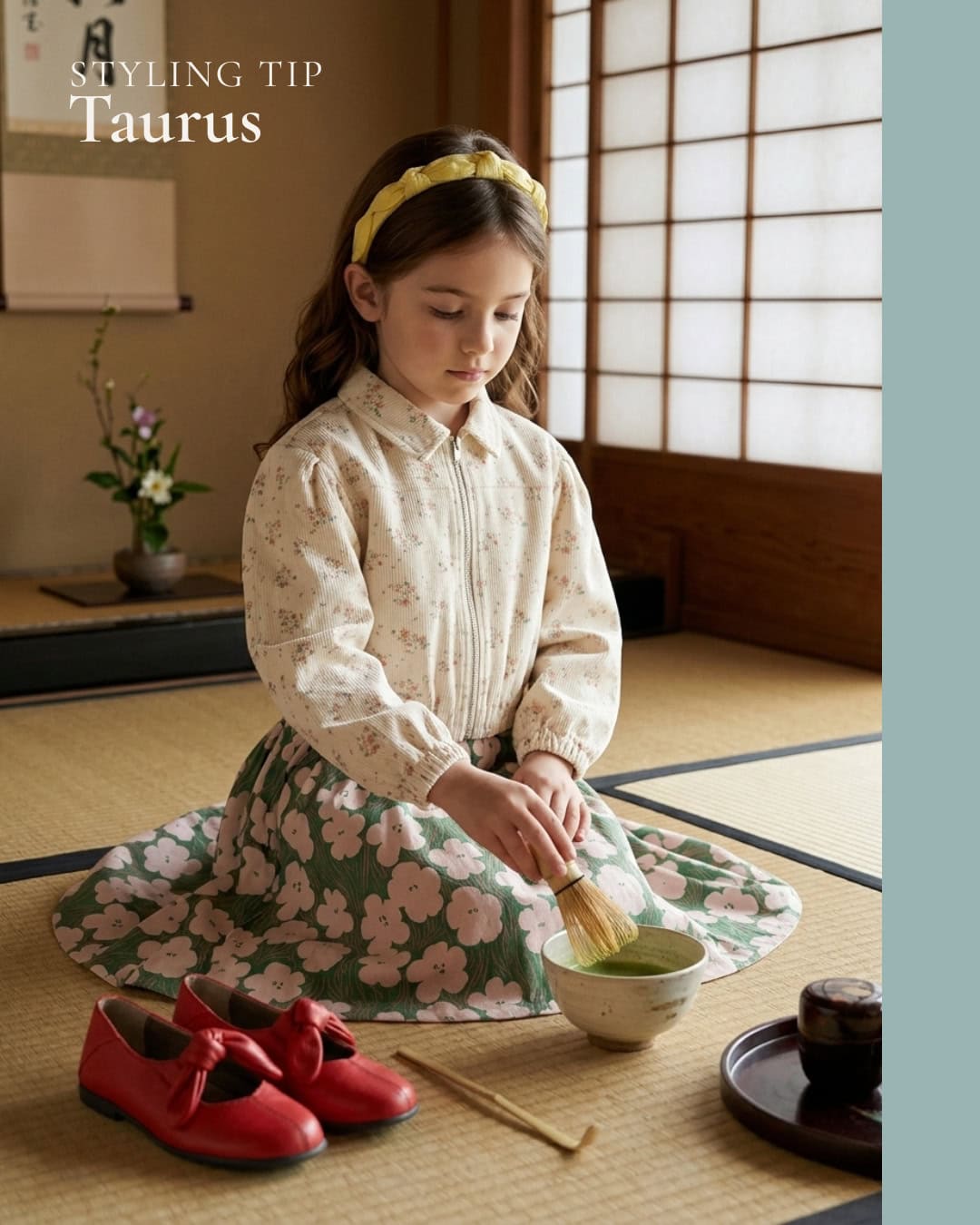 A young girl kneels on a tatami floor in a serene Japanese-style room, preparing matcha tea. She wears a cream floral blouse, a green skirt with soft pink flowers, a yellow headband and bright red bow shoes placed beside her. The styling blends vintage sweetness and playful elegance, with a calm, poetic atmosphere inspired by nature and ritual.