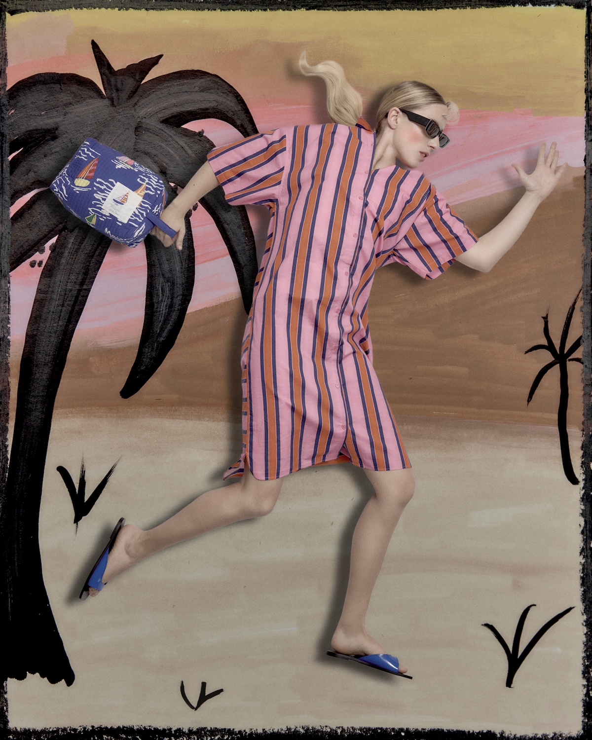 Woman in an oversized pink striped shirt dress and sunglasses, posed mid-run against a hand-painted beach scene with palm trees, carrying a small printed bag, capturing a whimsical resort mood.