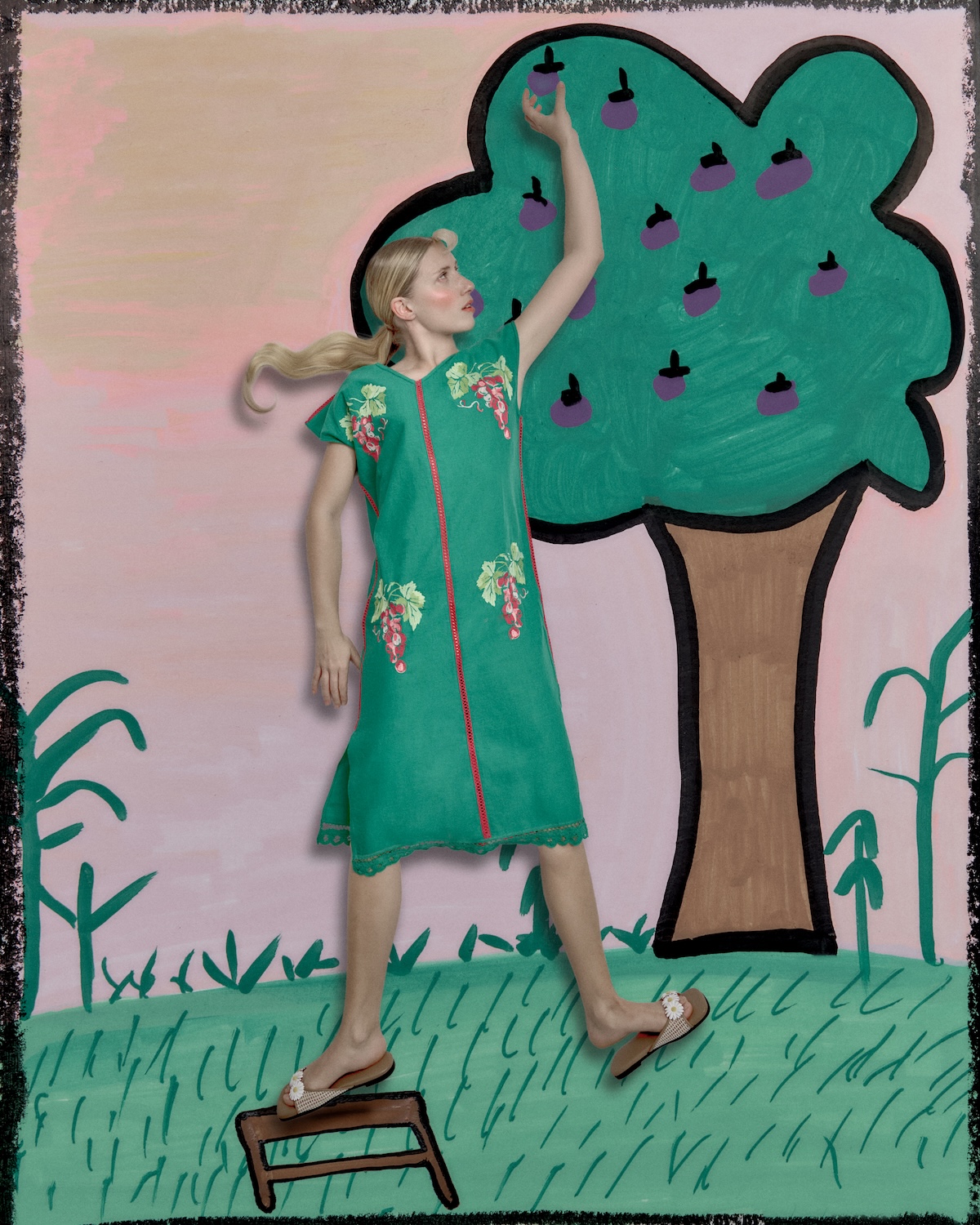 Woman in a green embroidered dress picking illustrated fruit from a painted tree, wearing daisy sandals, set in a whimsical garden scene with childlike artistic details.