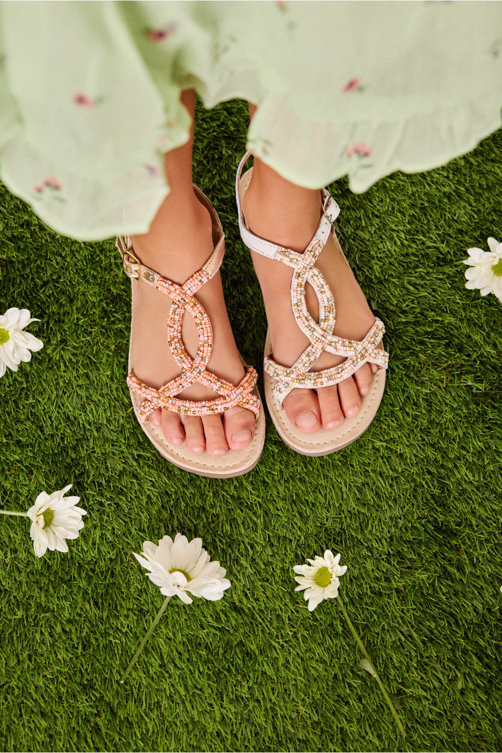 Close-up of beaded Gioseppo Kids SS26 sandals on grass with daisies, featured in the Freedom to Celebrate collection for Scimparello Magazine.