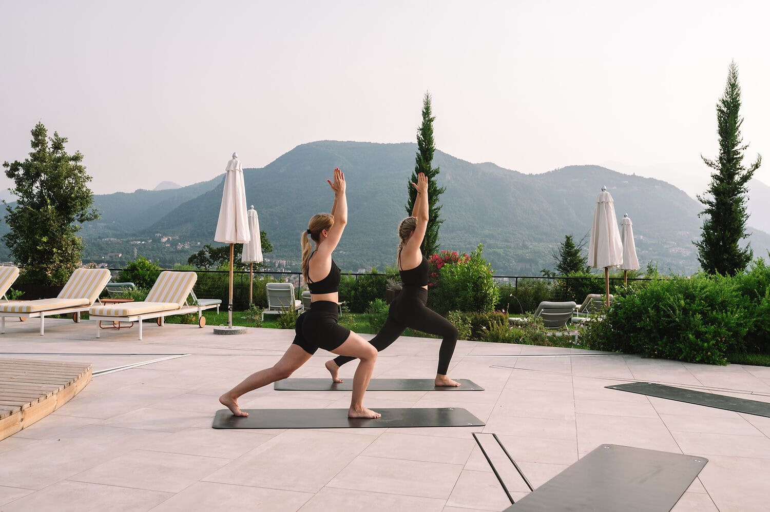 Morning yoga session overlooking Lake Garda at A-ROSA resort, surrounded by Mediterranean gardens and mountain scenery.