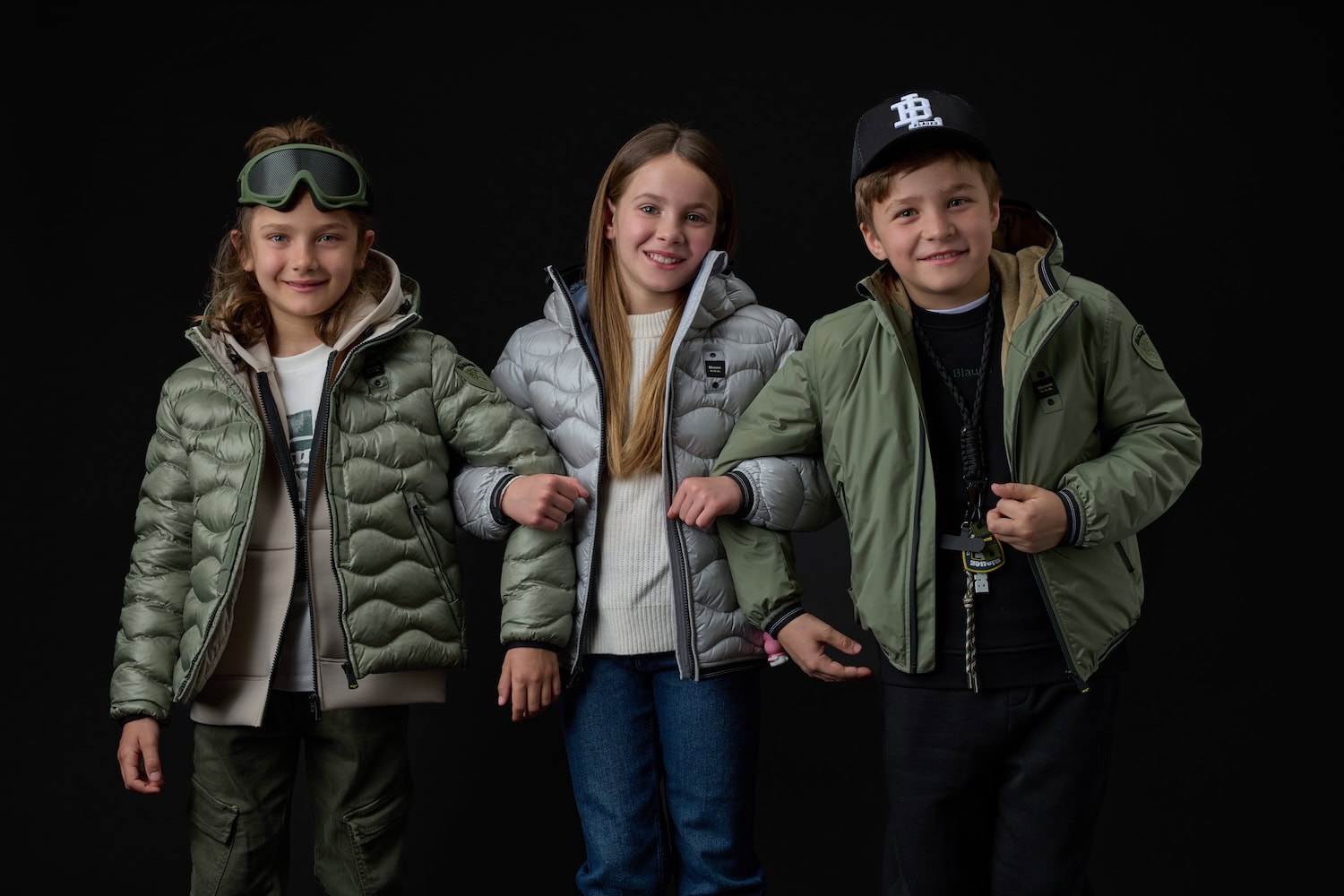 Three children wearing lightweight puffer jackets and outerwear in sage green and silver tones from the Blauer Junior FW26/27 collection.