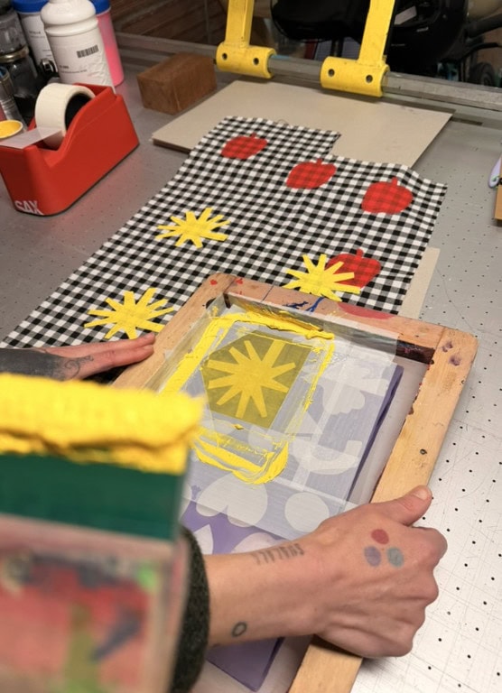 Anne-Charlotte Le Grand working on RE.Twist, a circular childrenswear project using screen printing, patches and creative upcycling to give pre-loved clothes a new life for Scimparello Magazine.