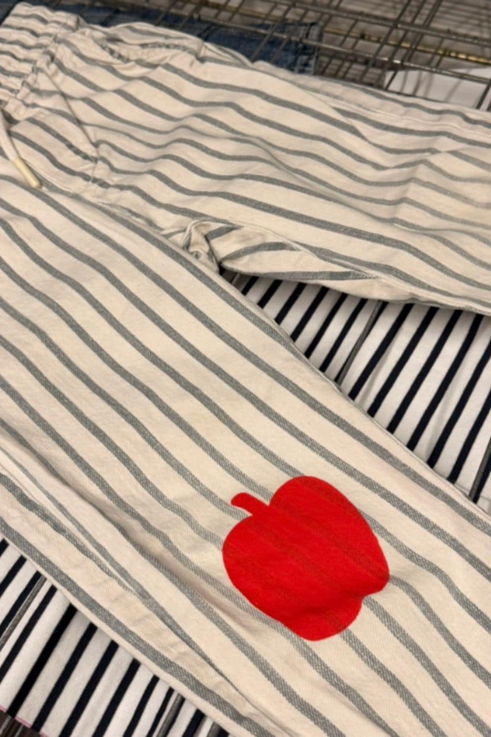 Striped children’s trousers transformed with a red apple patch for RE.Twist by Anne-Charlotte Le Grand, showing creative upcycling for pre-loved childrenswear on Scimparello Magazine.