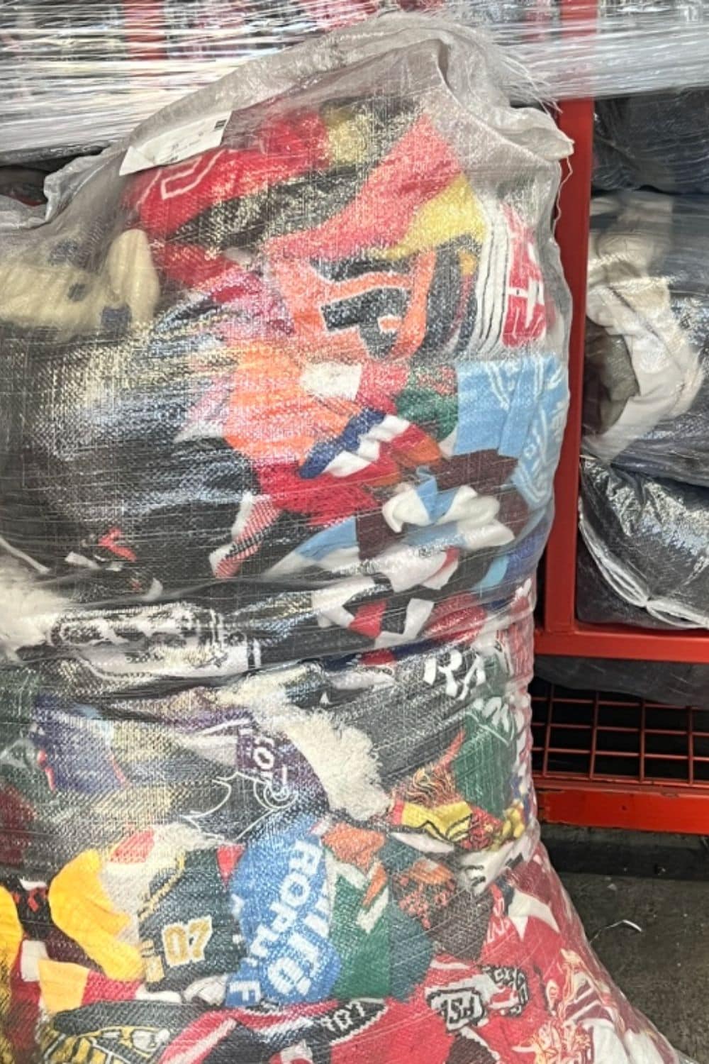 Large compressed bale of discarded children’s clothes wrapped in plastic, showing the volume of textile waste behind RE.Twist by Anne-Charlotte Le Grand for Scimparello Magazine.