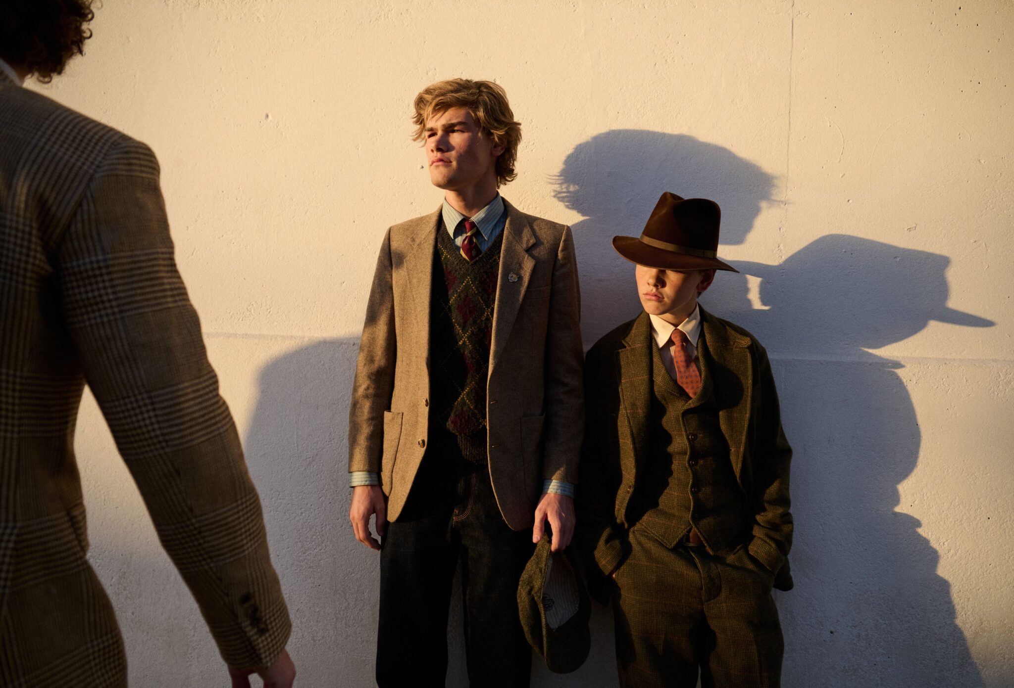 Three boys wearing Ralph Lauren tailored suits, ties and heritage layers in warm evening light for Ralph Brothers, a kids fashion editorial photographed by Tim Marsella for Scimparello Magazine.