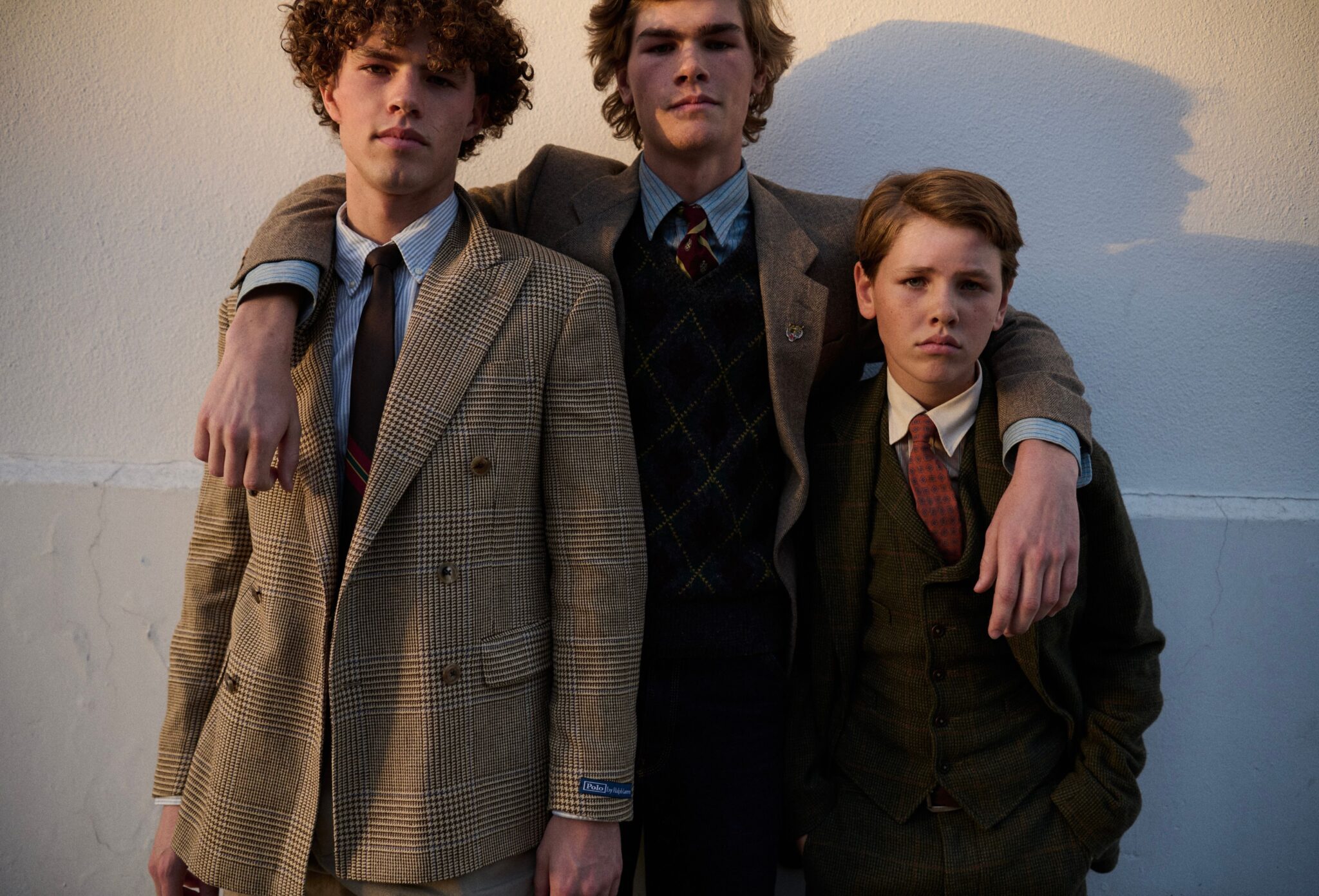 Three brothers wearing Ralph Lauren tailored suits, shirts, ties and heritage layers in warm evening light for Ralph Brothers, a kids fashion editorial photographed by Tim Marsella for Scimparello Magazine.