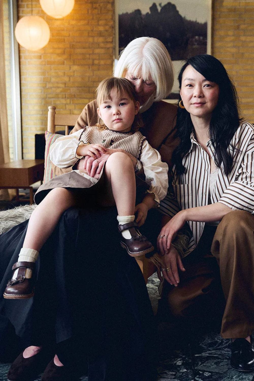 Three generations of a family sitting together, with a young child wearing classic Bundgaard shoes, celebrating the intergenerational spirit of the Bundgaard Generations campaign.