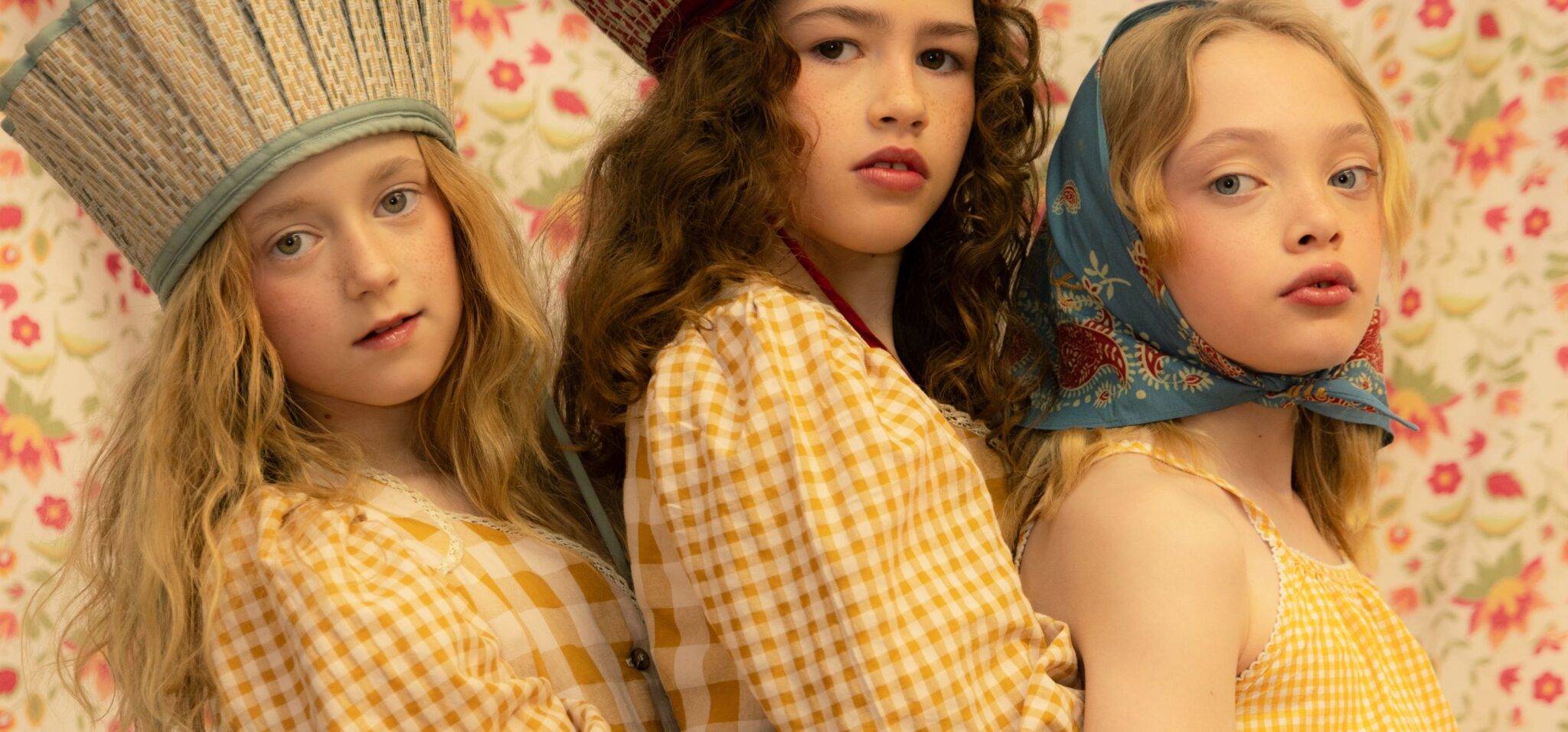 Kids fashion editorial Unscripted photographed by Marta Migacz and styled by Eva Rayner, featuring girls in yellow gingham looks, sculptural headpieces and floral styling for Scimparello Magazine.