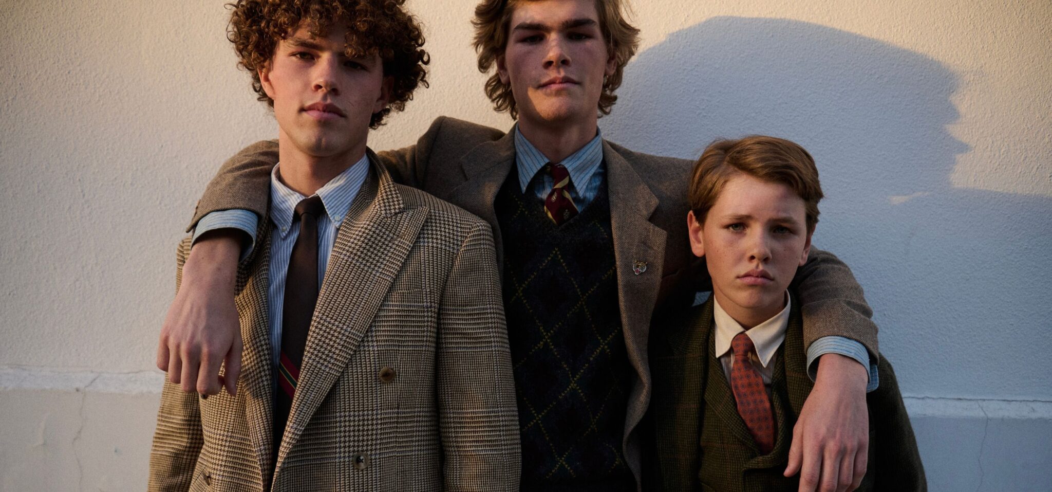 Three brothers wearing Ralph Lauren tailored suits, shirts, ties and heritage layers in warm evening light for Ralph Brothers, a kids fashion editorial photographed by Tim Marsella for Scimparello Magazine.