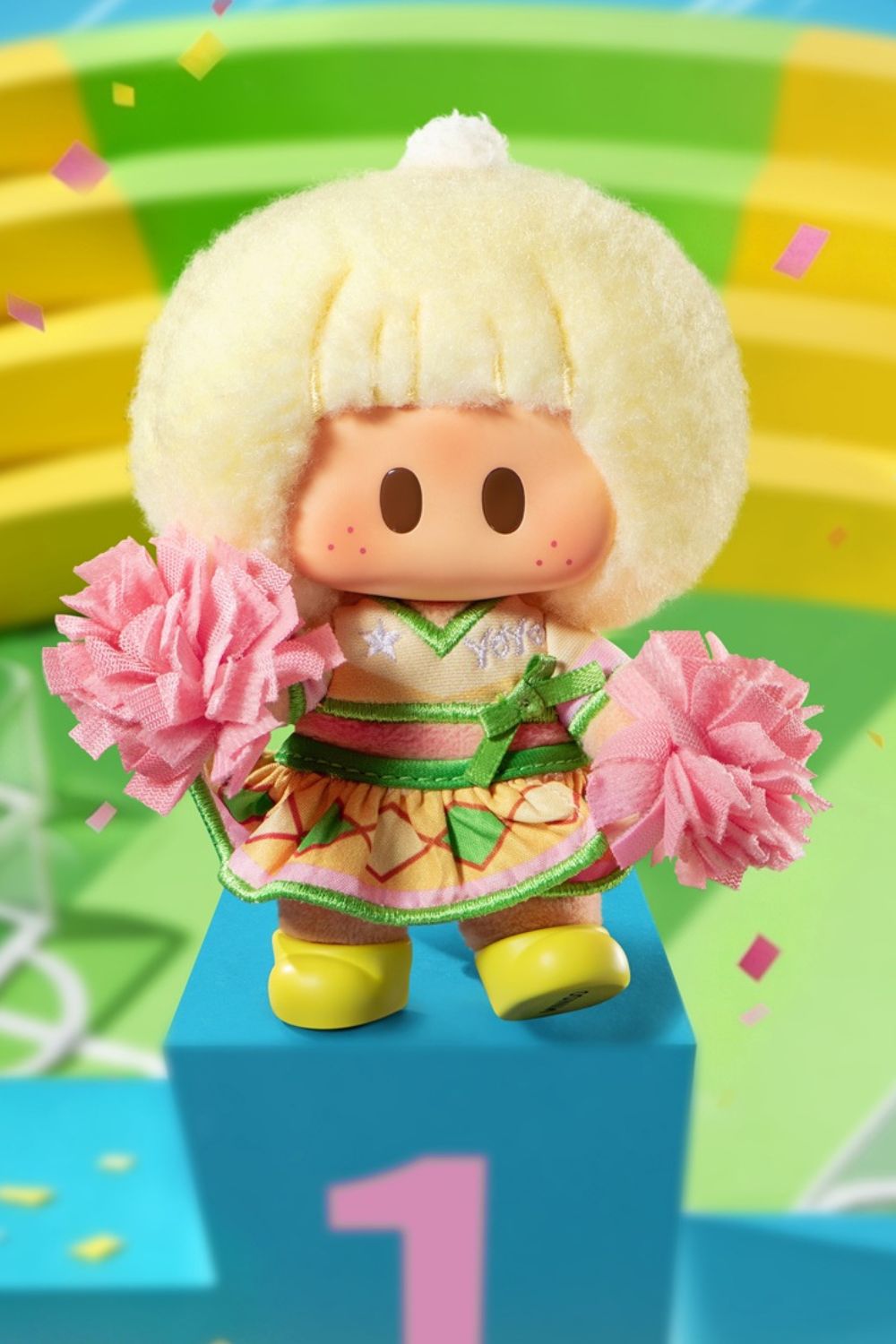 MINISO YOYO collectible figure dressed as a cheerleader with fluffy blonde hair, pink pom-poms and a colorful outfit, standing on a winner's podium against a playful sports-themed background.