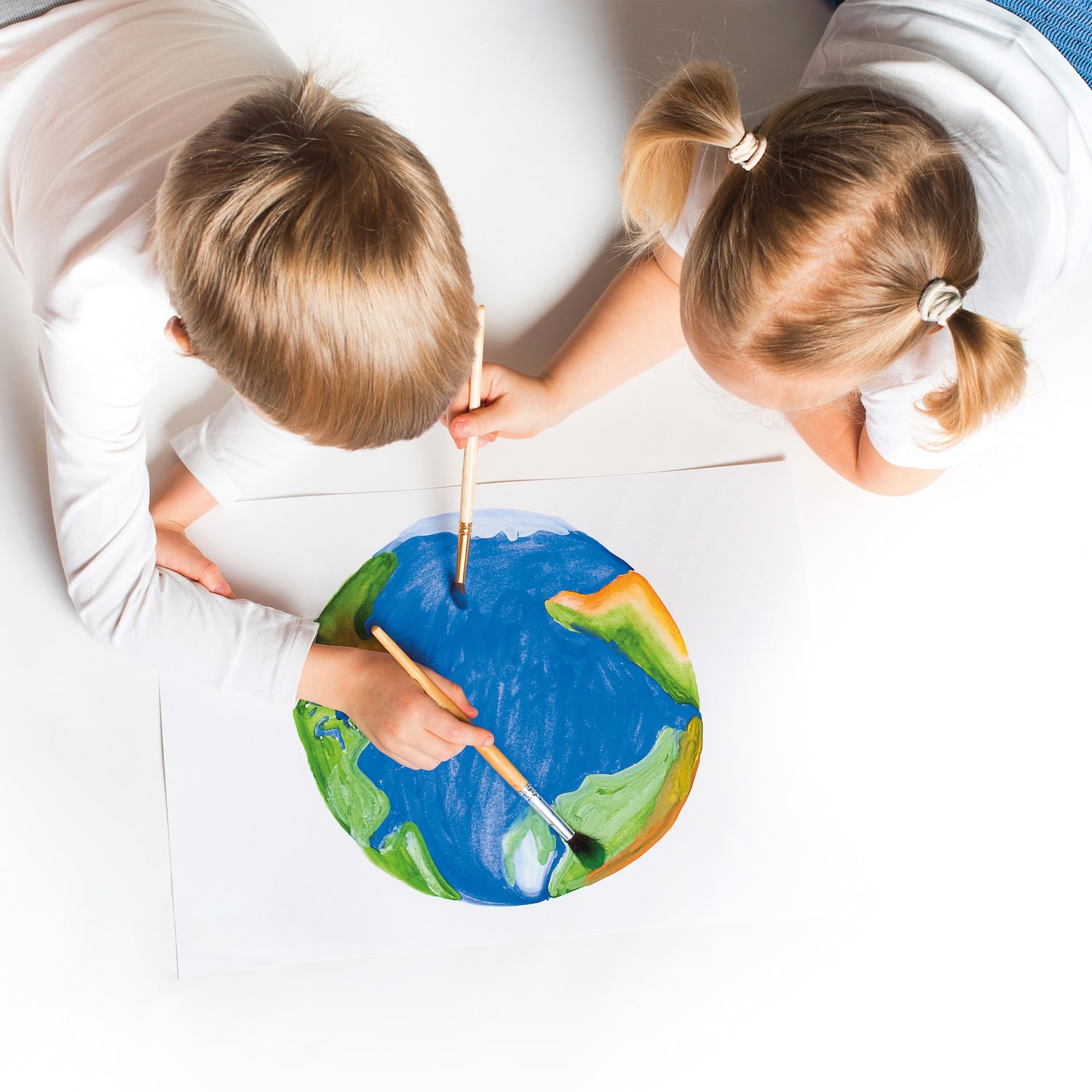 Two children painting a colorful Earth with brushes during a creative art activity using washable paints, encouraging imagination, hands-on learning and artistic expression.