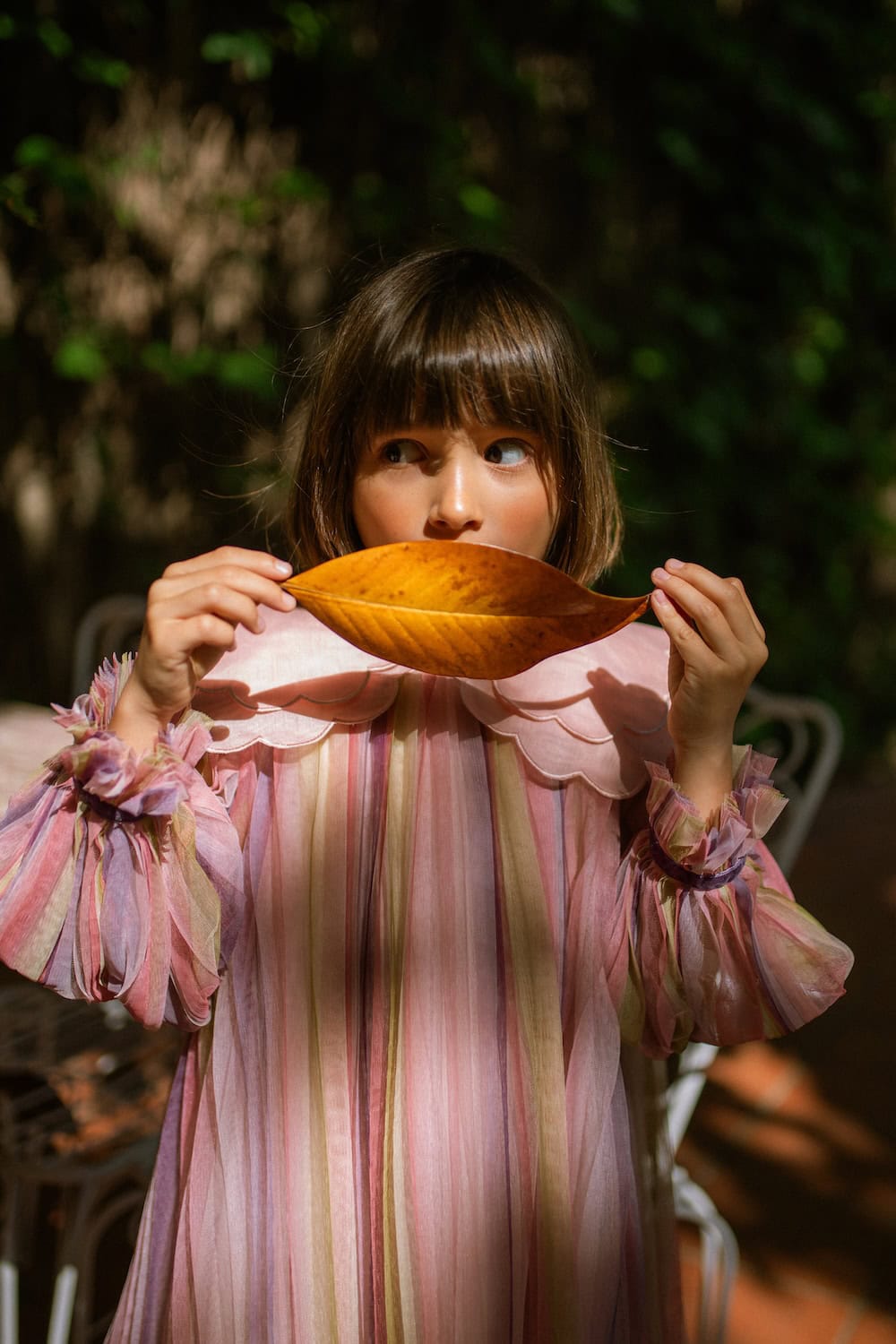 Girl wearing a pastel striped dress with an oversized scalloped collar from the C'era Una Volta Fall Winter 2026 collection.