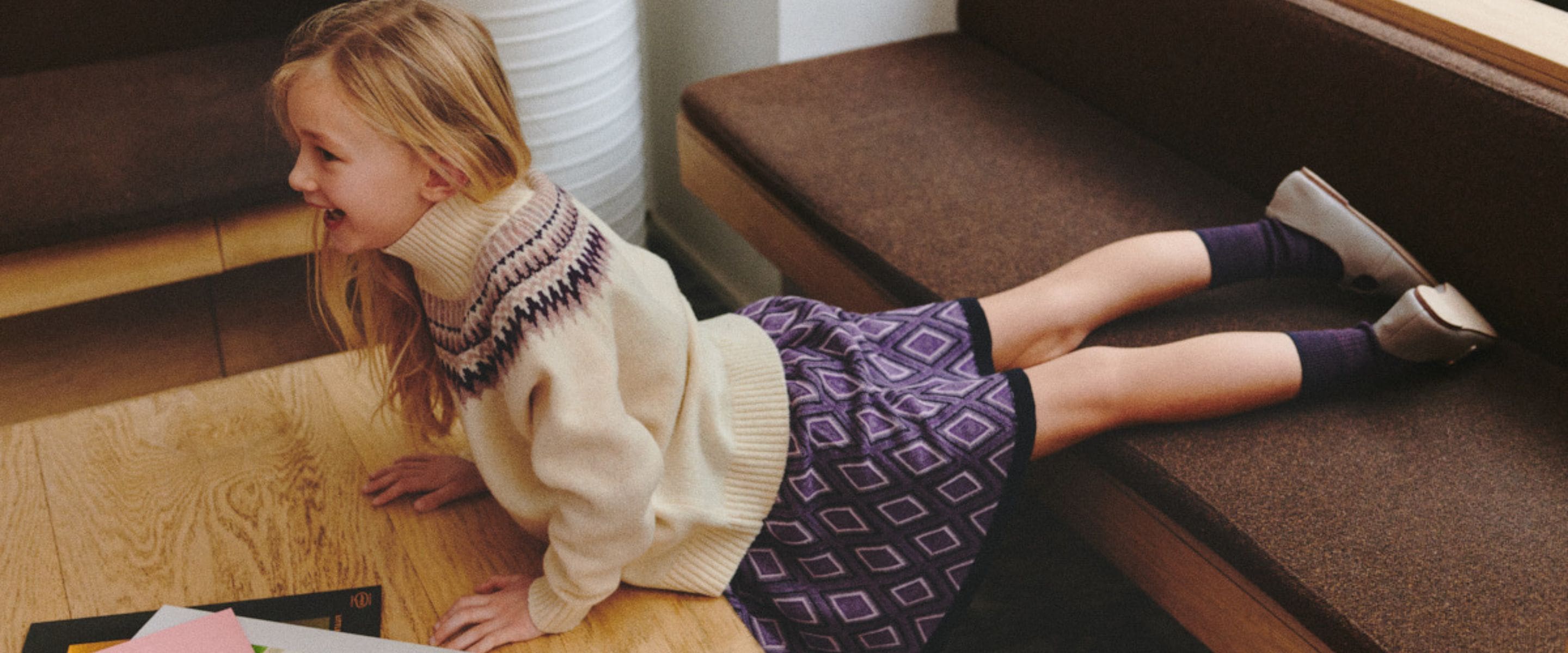 Girl wearing a cream Fair Isle turtleneck sweater with a purple geometric knitted skirt from the FUB Kids Autumn Winter 2026 collection.