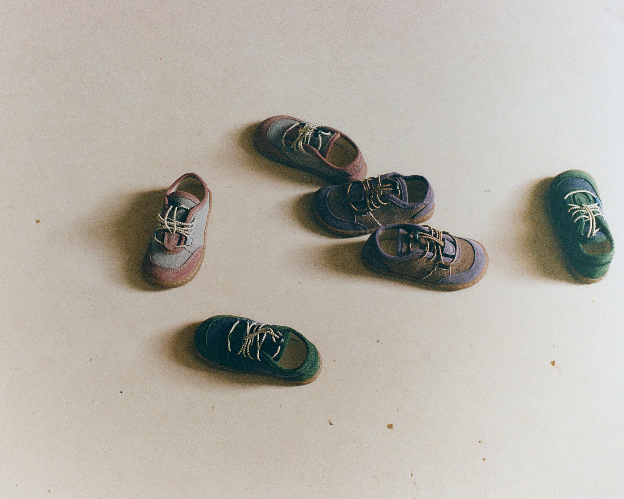 Flat lay of Maior barefoot children's shoes in multiple earthy colourways arranged on a neutral background.