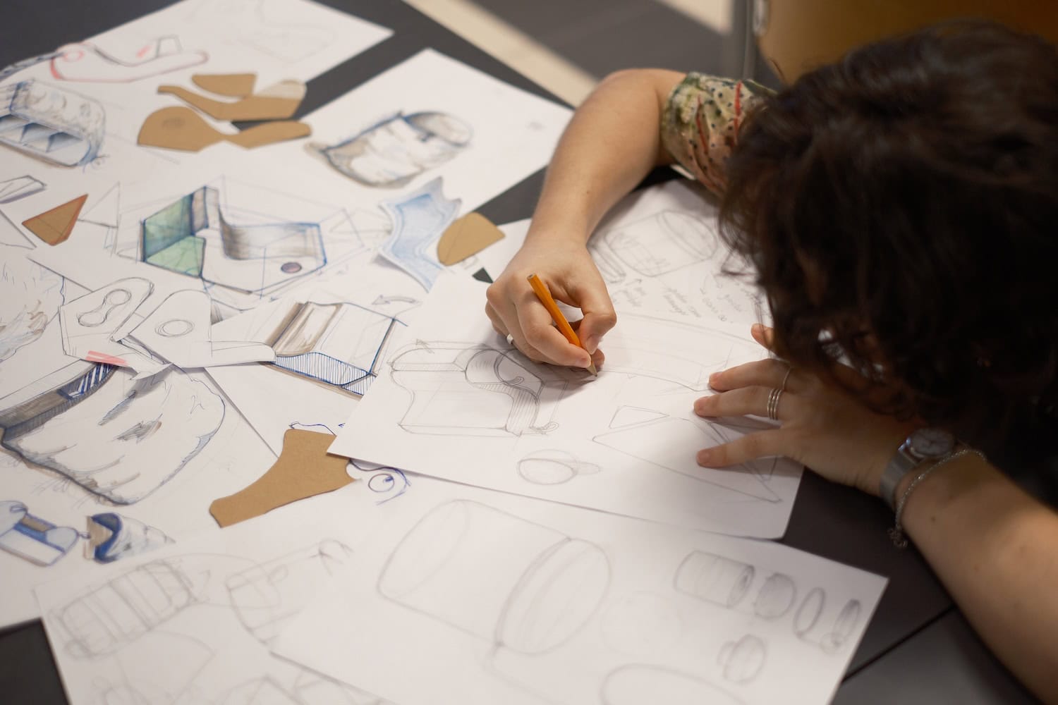 Close-up of a design student sketching furniture concepts during the Wear & Grow workshop, exploring adaptable and sustainable interior solutions for children and teenagers through hand-drawn product designs.