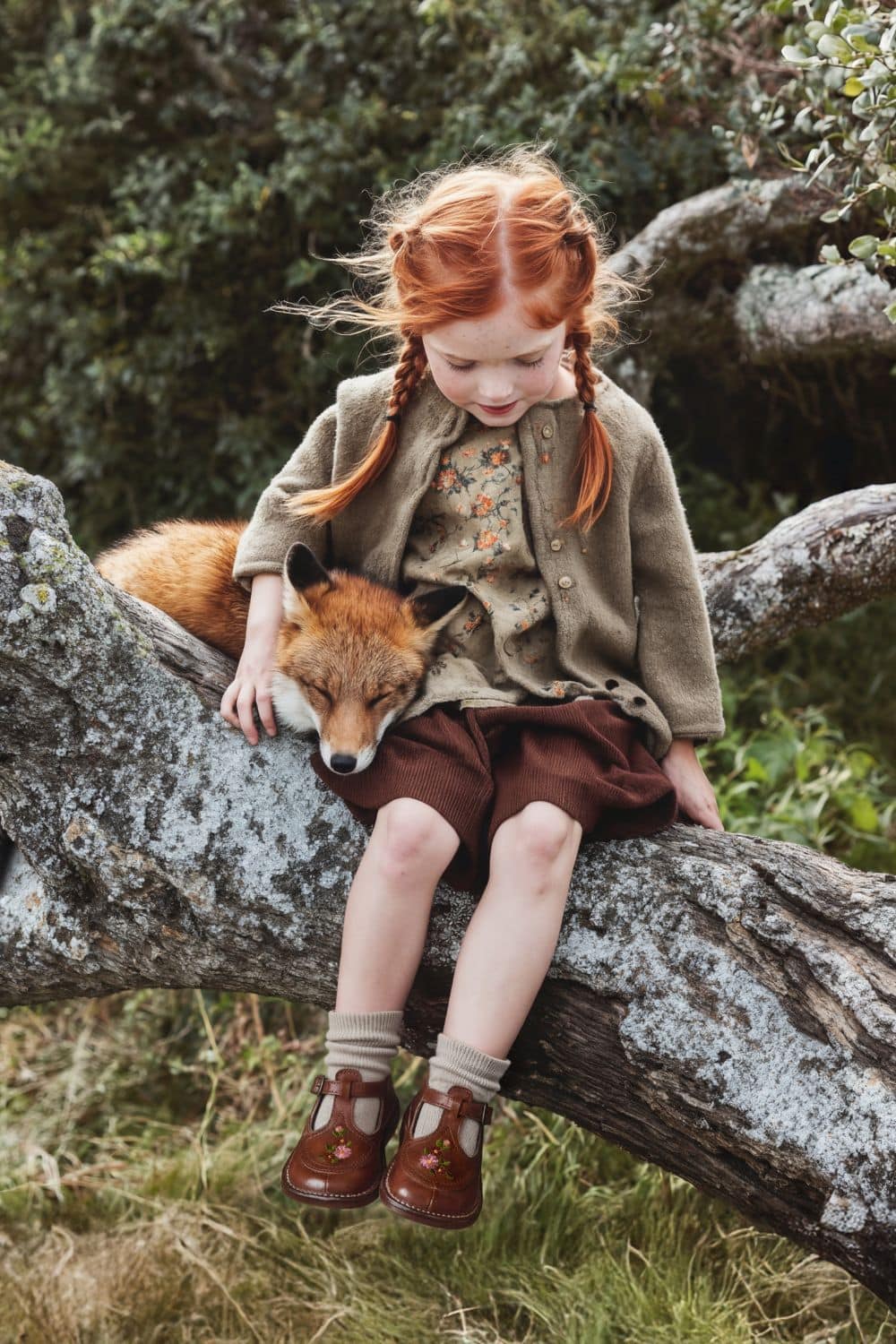 Pèpè Children Shoes FW26 collection, featuring a girl wearing brown leather T-bar shoes with floral embroidery in a woodland setting for Scimparello Magazine.