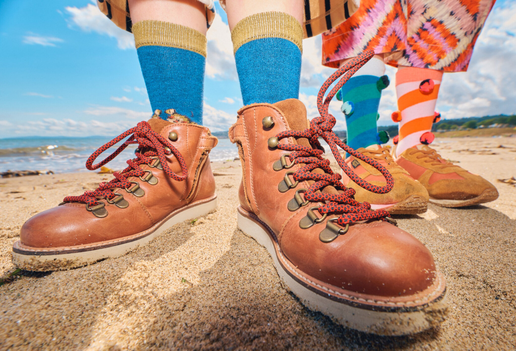 Forecast: Colour FW26 fashion editorial photographed by Alma Rosaz, featuring close-up details of colourful socks and leather boots on the sand for Scimparello Magazine.
