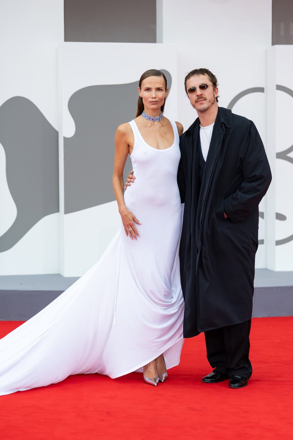 Glenn Martens and Natasha Poly posing together on the red carpet at the Venice Film Festival.