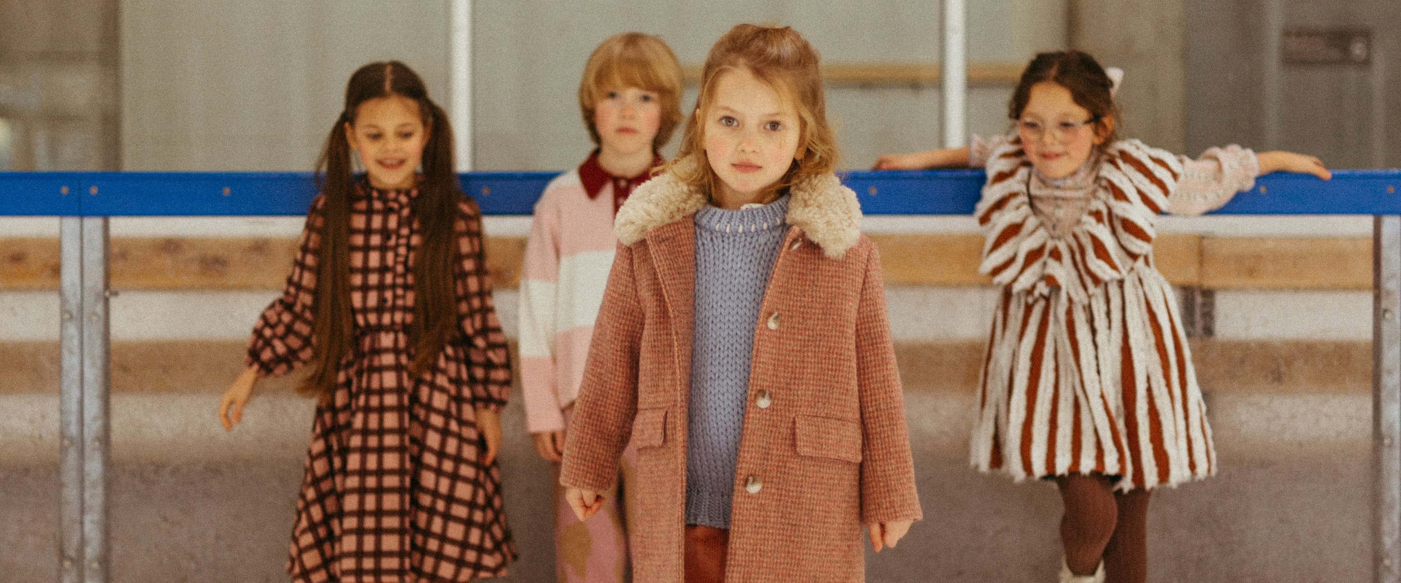 Paade Mode THE STARBOUND FW26 collection header image, featuring children at an ice rink in warm layered winter looks for Scimparello Magazine.
