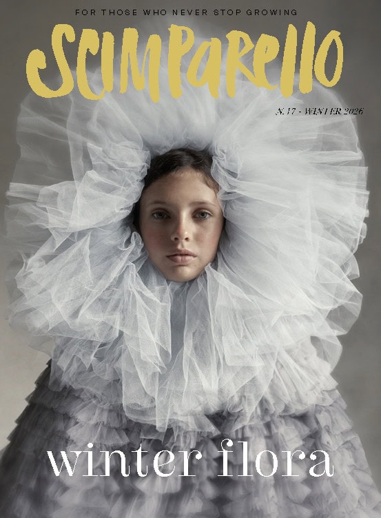 Cover of Scimparello N°17 Winter 2026, Winter Flora: a child wrapped in a huge cloud of pale grey tulle, with the yellow Scimparello logo above and 
