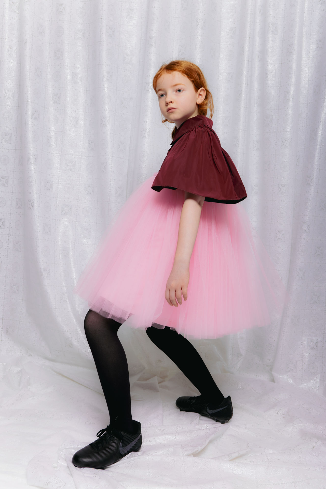 Christina Rohde AW26 pink tulle skirt and burgundy cape top styled with black tights and chunky shoes
