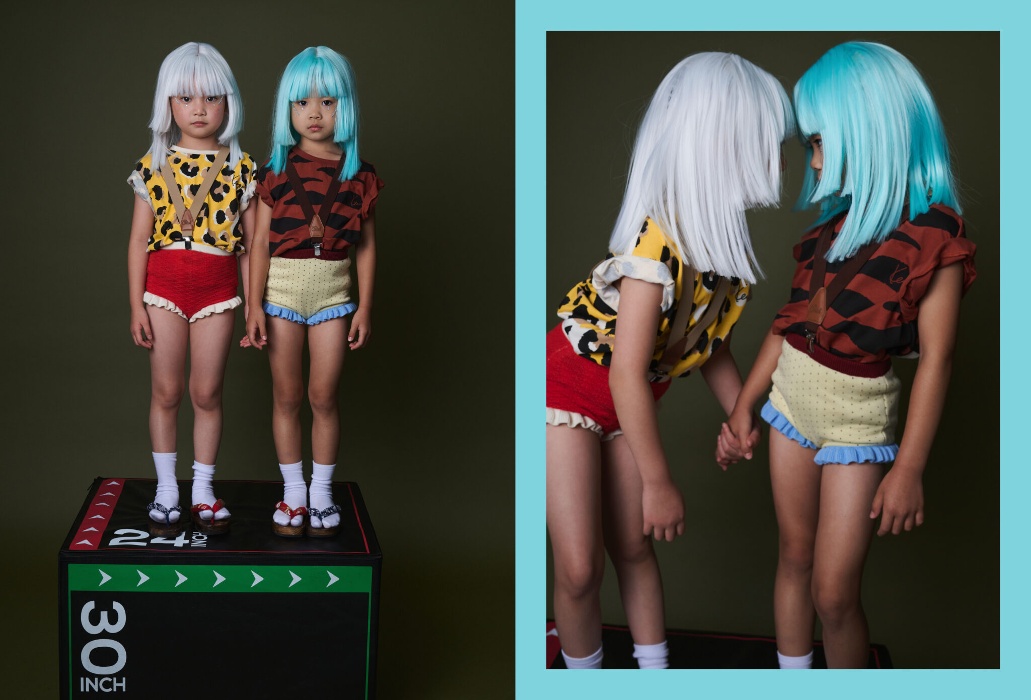 Two girls in white and turquoise wigs, leopard and tiger print T-shirts and knit bloomers standing on a plyo box, then touching foreheads